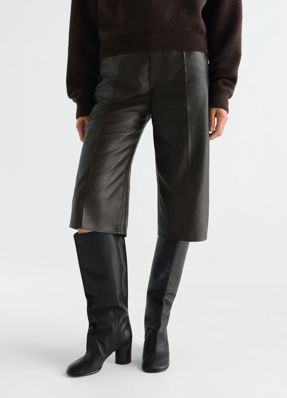 STIEFEL MIT BÜGELFALTEN-SCHAFT AUS WEICHEM, GLÄNZENDEM LEDER, in Schwarz, von einem Model getragen, Vorderansicht