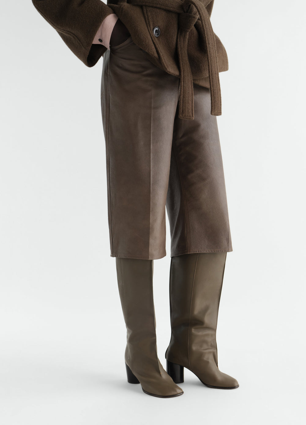 STIEFEL MIT BÜGELFALTEN-SCHAFT AUS WEICHEM, GLÄNZENDEM LEDER, in Oliv, von einem Model getragen