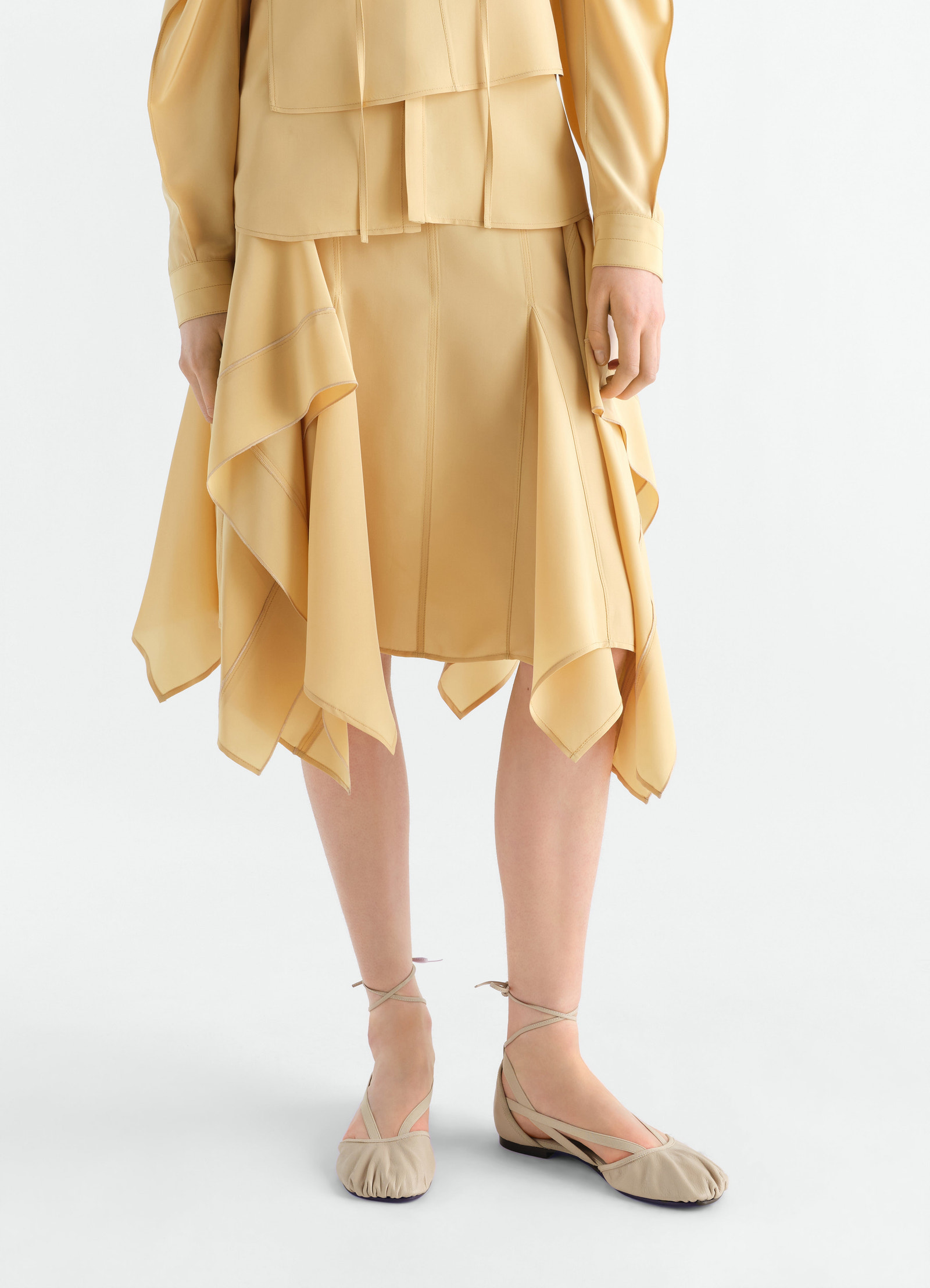 Flat pedille ballerinas in beige goat leather lemaire worn by model front view with ankle straps
