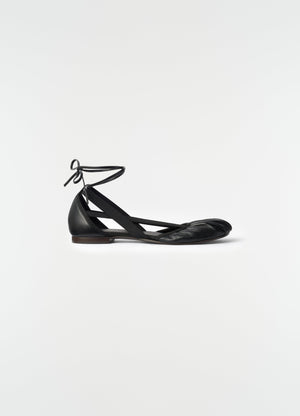 Flat pedille ballerinas in black goat leather with ankle ties lemaire side view on plain white background
