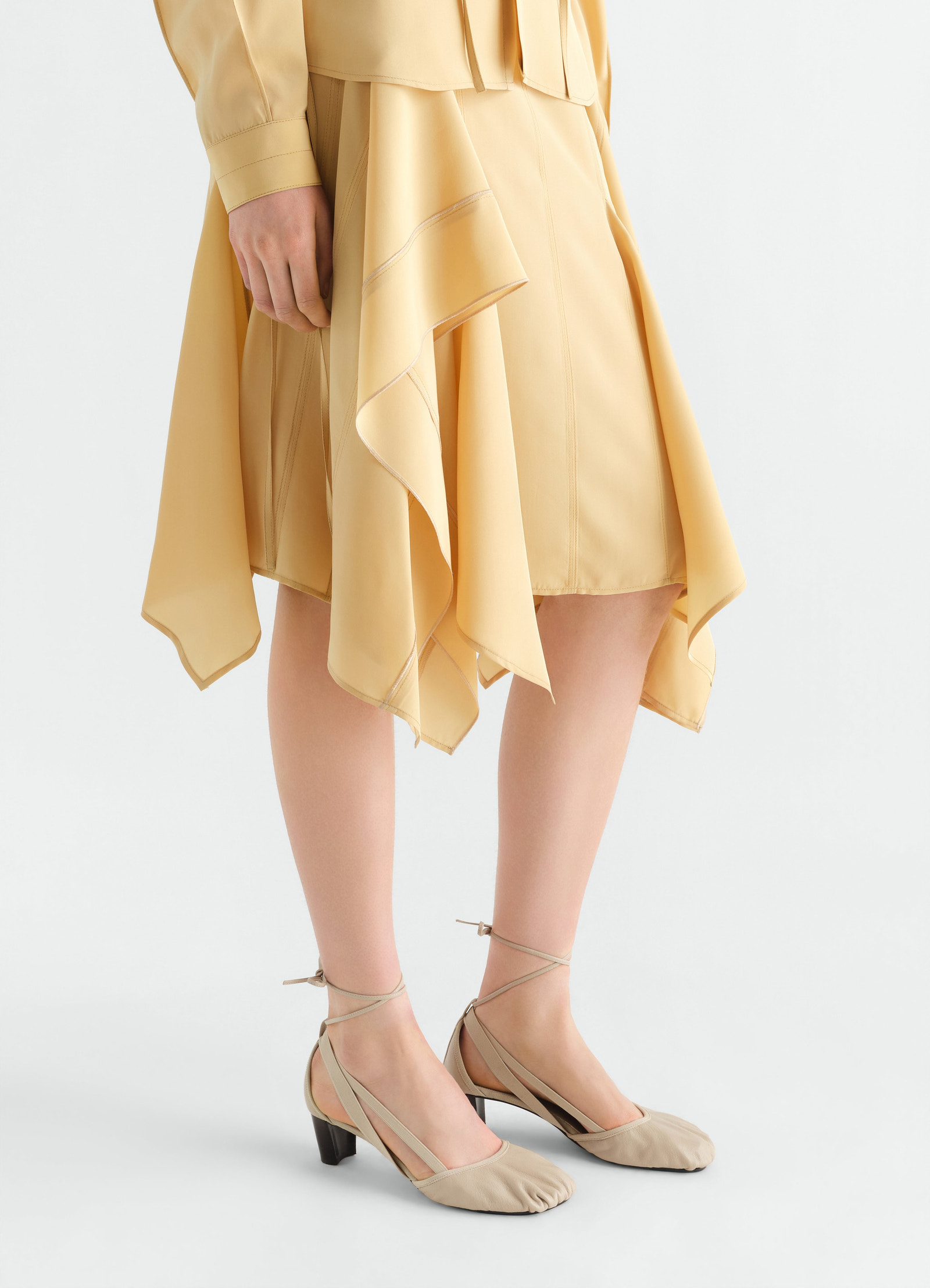 Ballerines à talons 55 mm pedille en cuir de chèvre, coloris beige, porté par un mannequin, vue de profil, talon visible