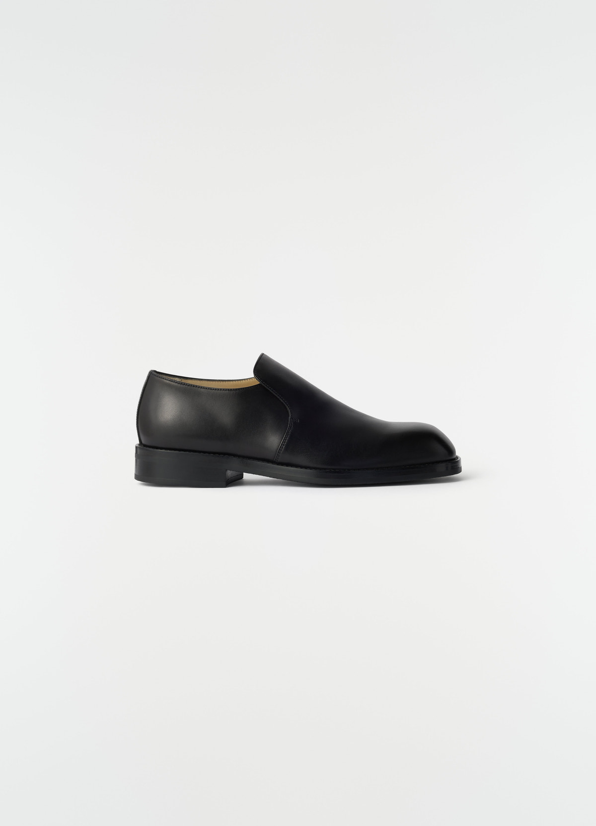 Formal black shiny leather loafers lemaire side view on plain white background