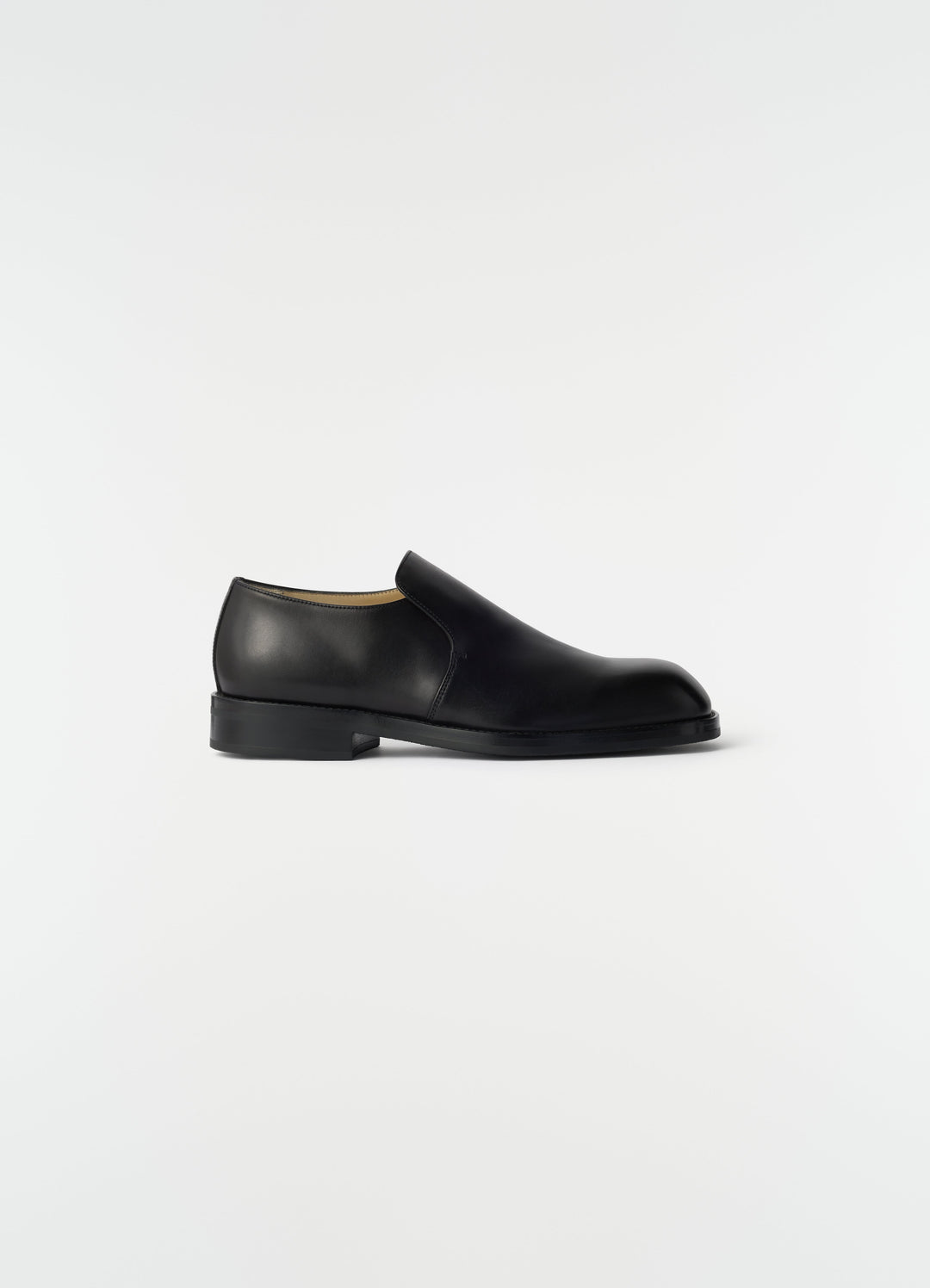 Formal black shiny leather loafers LEMAIRE side view on plain white background