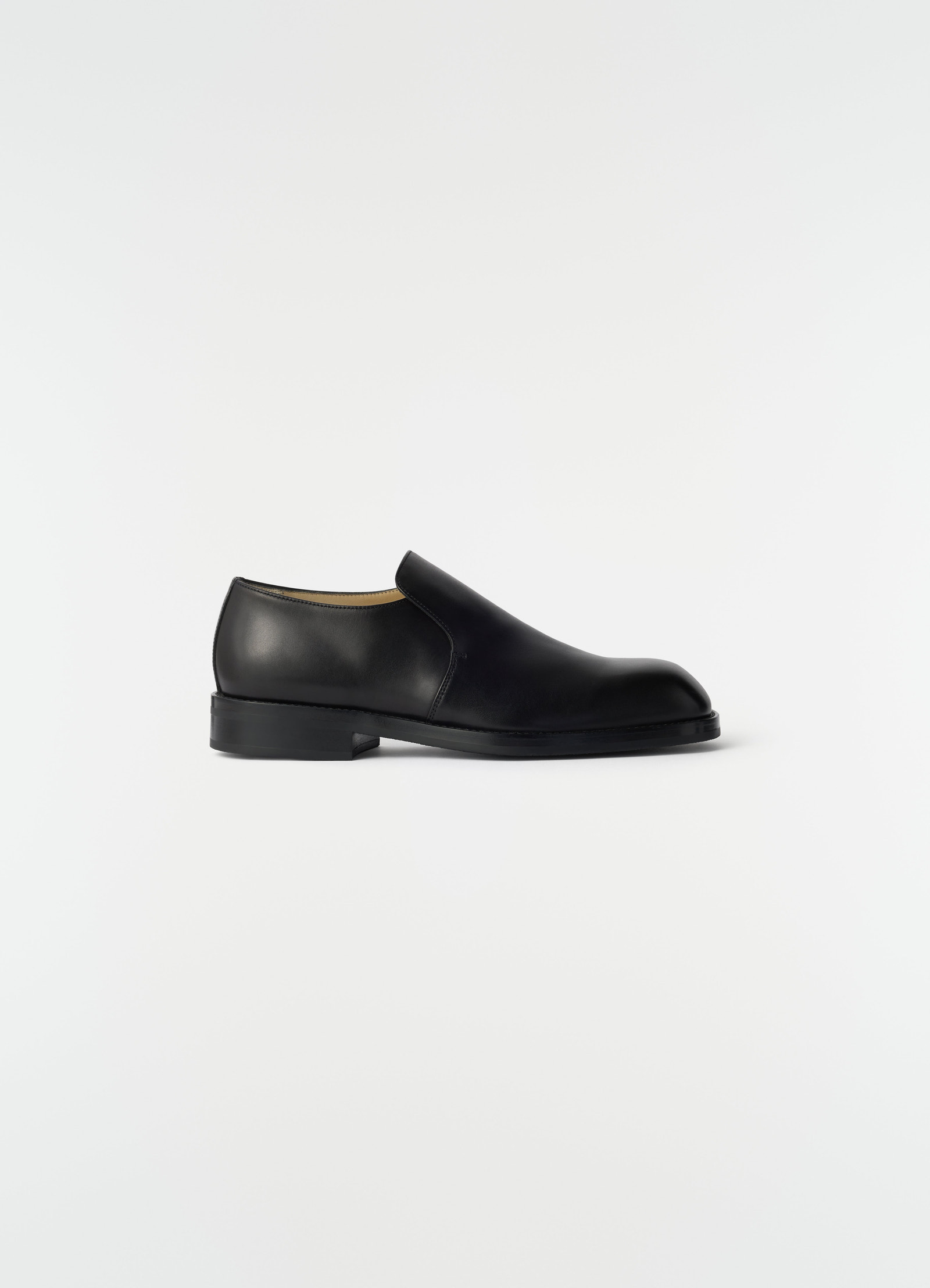 Formal black shiny leather loafers lemaire side view on plain white background