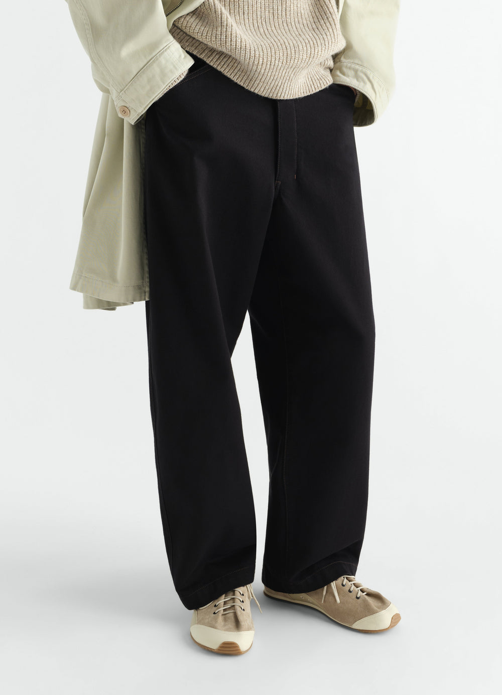 Gummy Grips beige leather sneakers by LEMAIRE worn by model front view with black pants and beige sweater