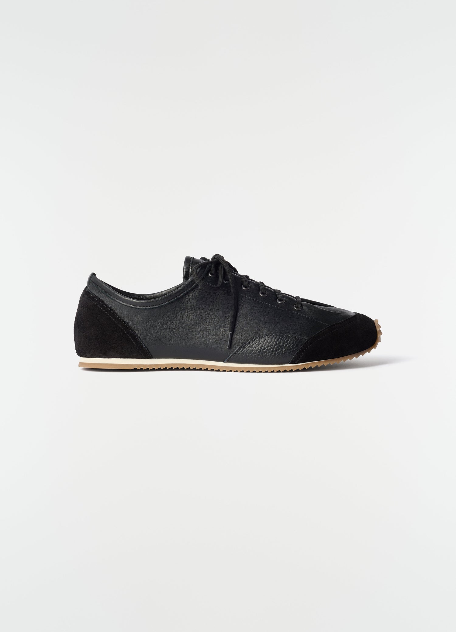 Gummy Grips sneakers in black mixed leather with rubber sole by LEMAIRE side view on white background