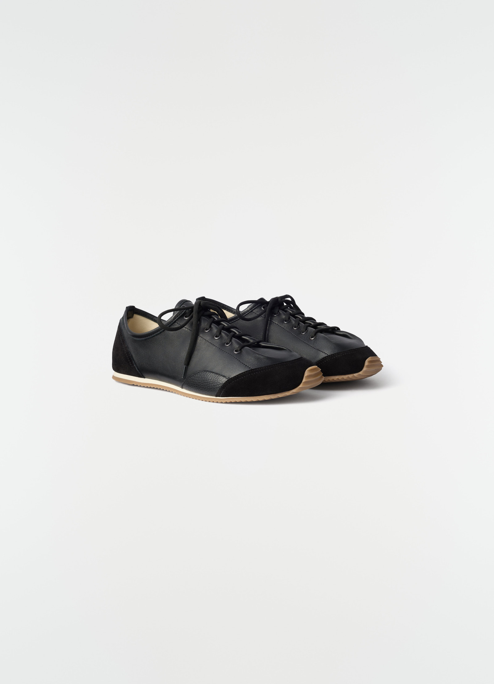 Gummy grips sneakers in black mixed leather with gum sole by lemaire styled side view on white background