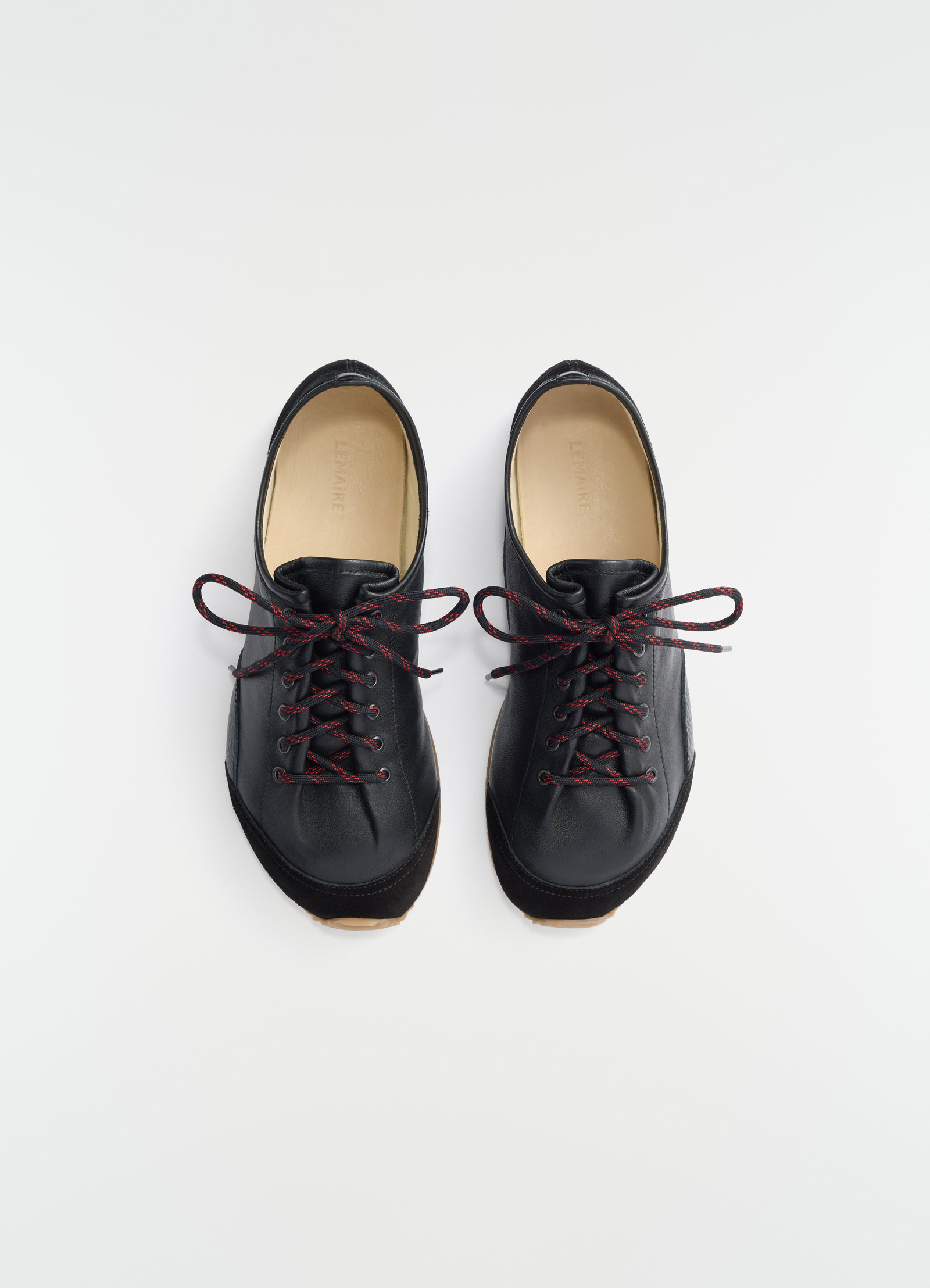 Gummy grips black mixed leather sneakers with red laces by lemaire front view on white background