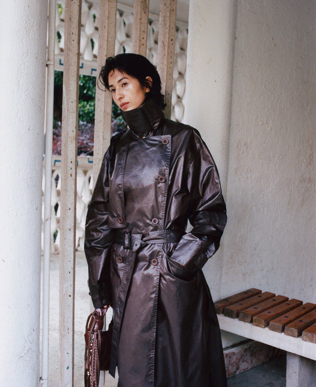 Shiny trench coat in Dark brown shiny material, model shot, Worn view Double-breasted with belt