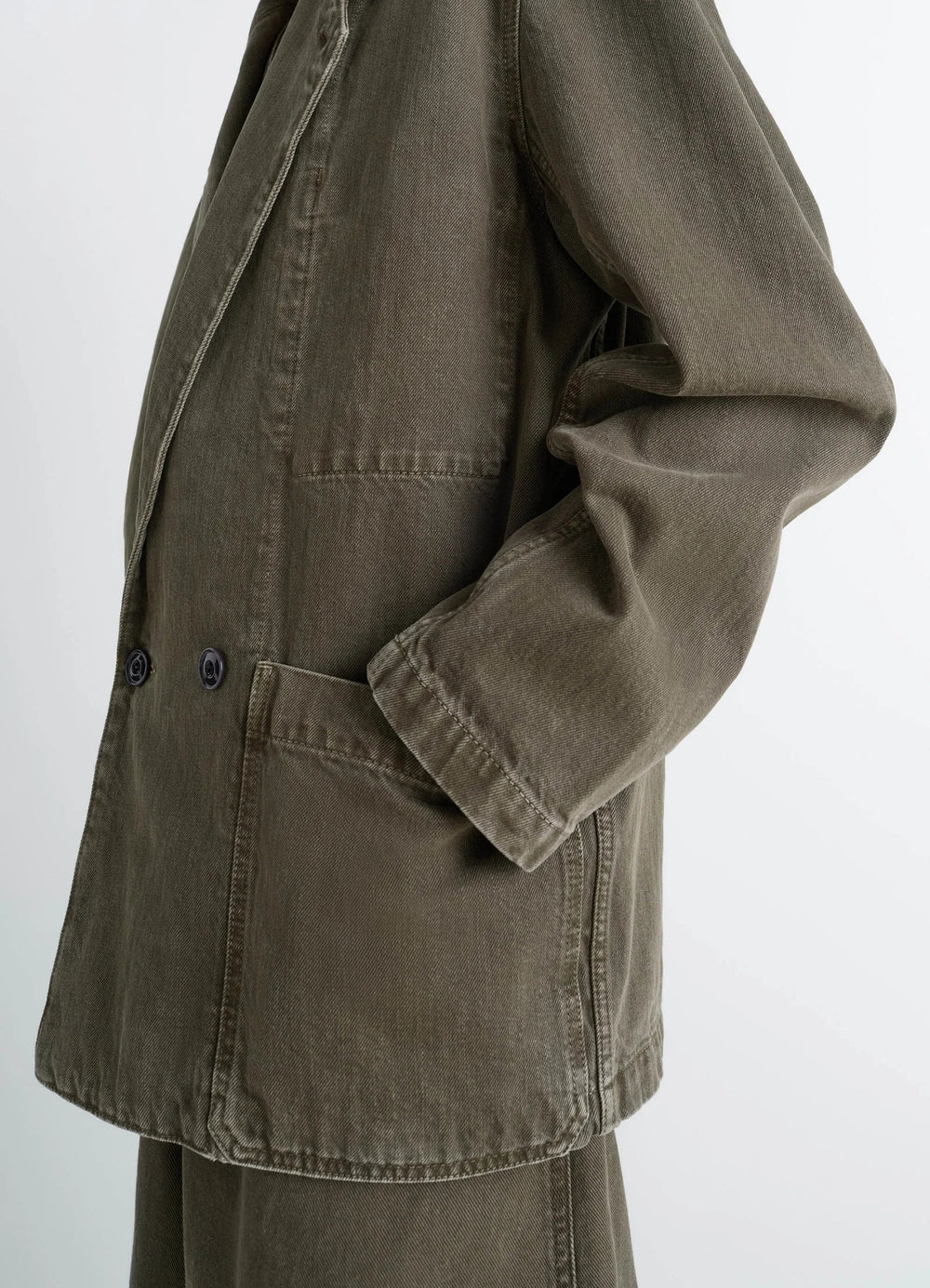 Lemaire Workwear Blazer in Garment Dyed Snow Denim, model shot, side profile view relaxed sleeve drape