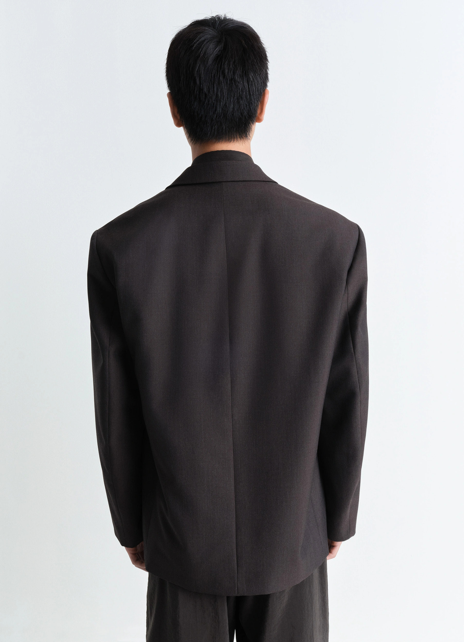 Lemaire soft double breasted jacket in tropical poly-wool mélange twill, model shot, back view ventless design