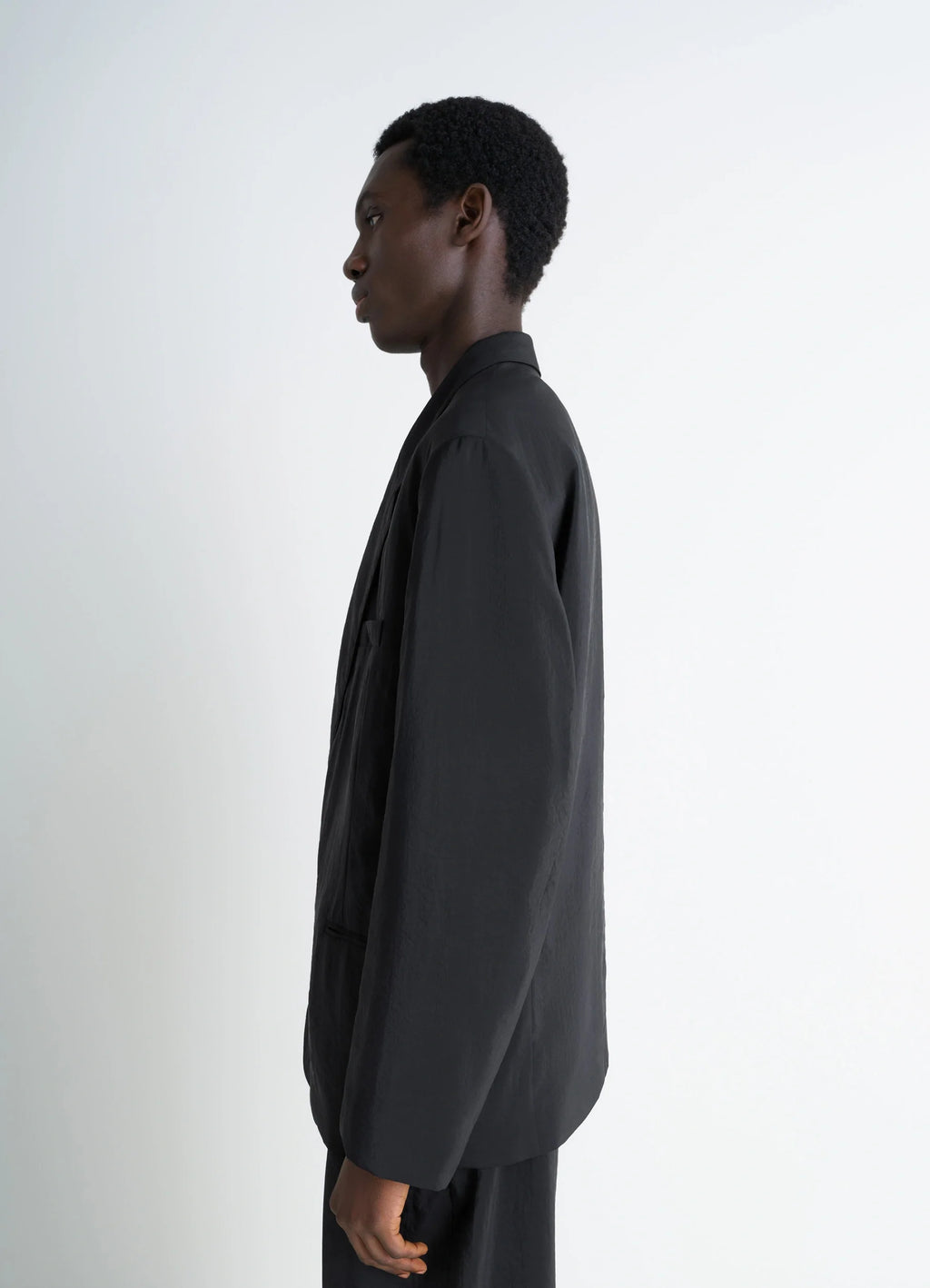 Lemaire Soft Double Breasted Jacket in Black Dry Silk Blend, model shot, side profile view structured shoulder