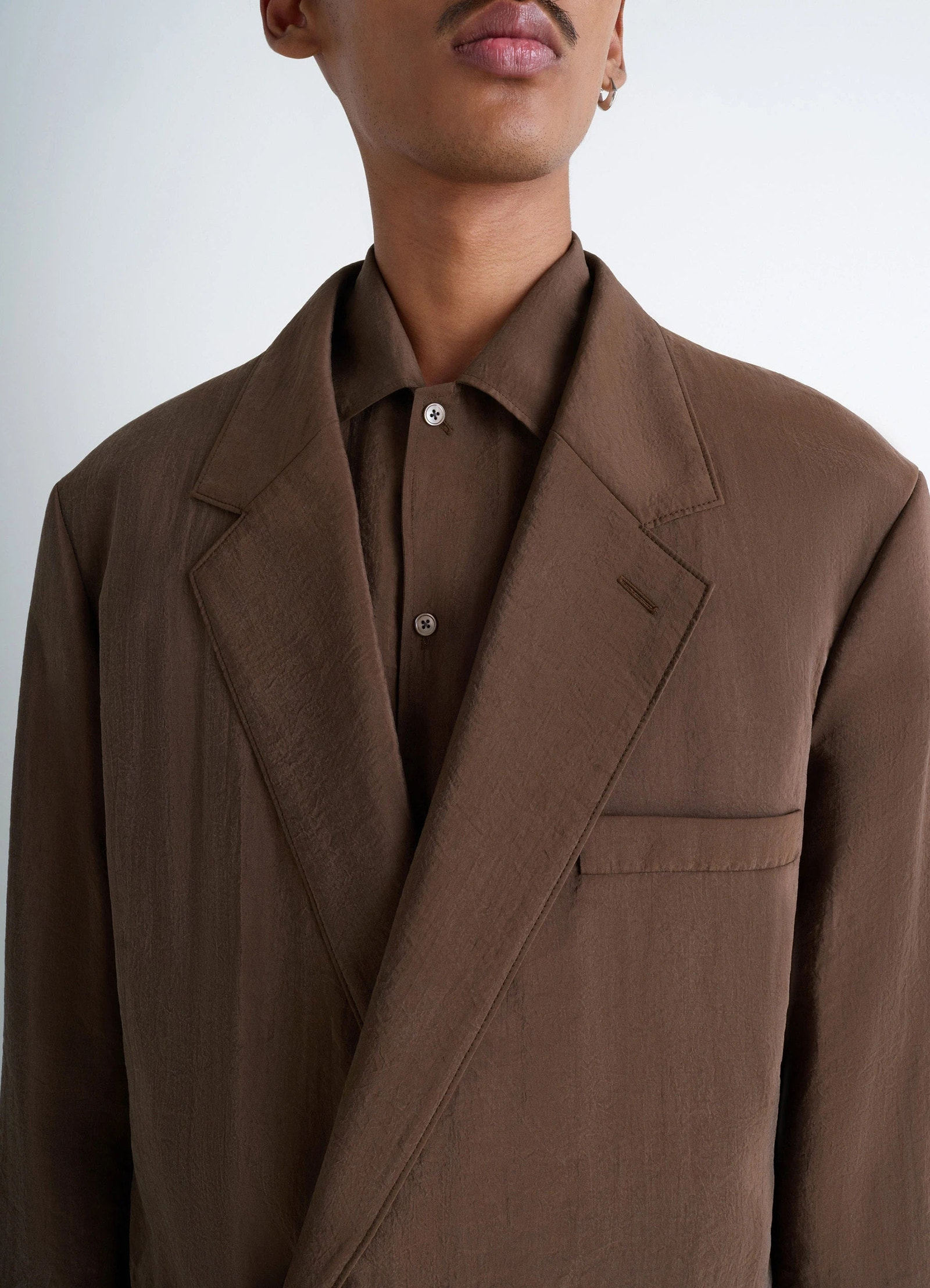 Lemaire soft double-breasted jacket in heather brown dry silk blend, model shot, close-up side view lapel and button detail