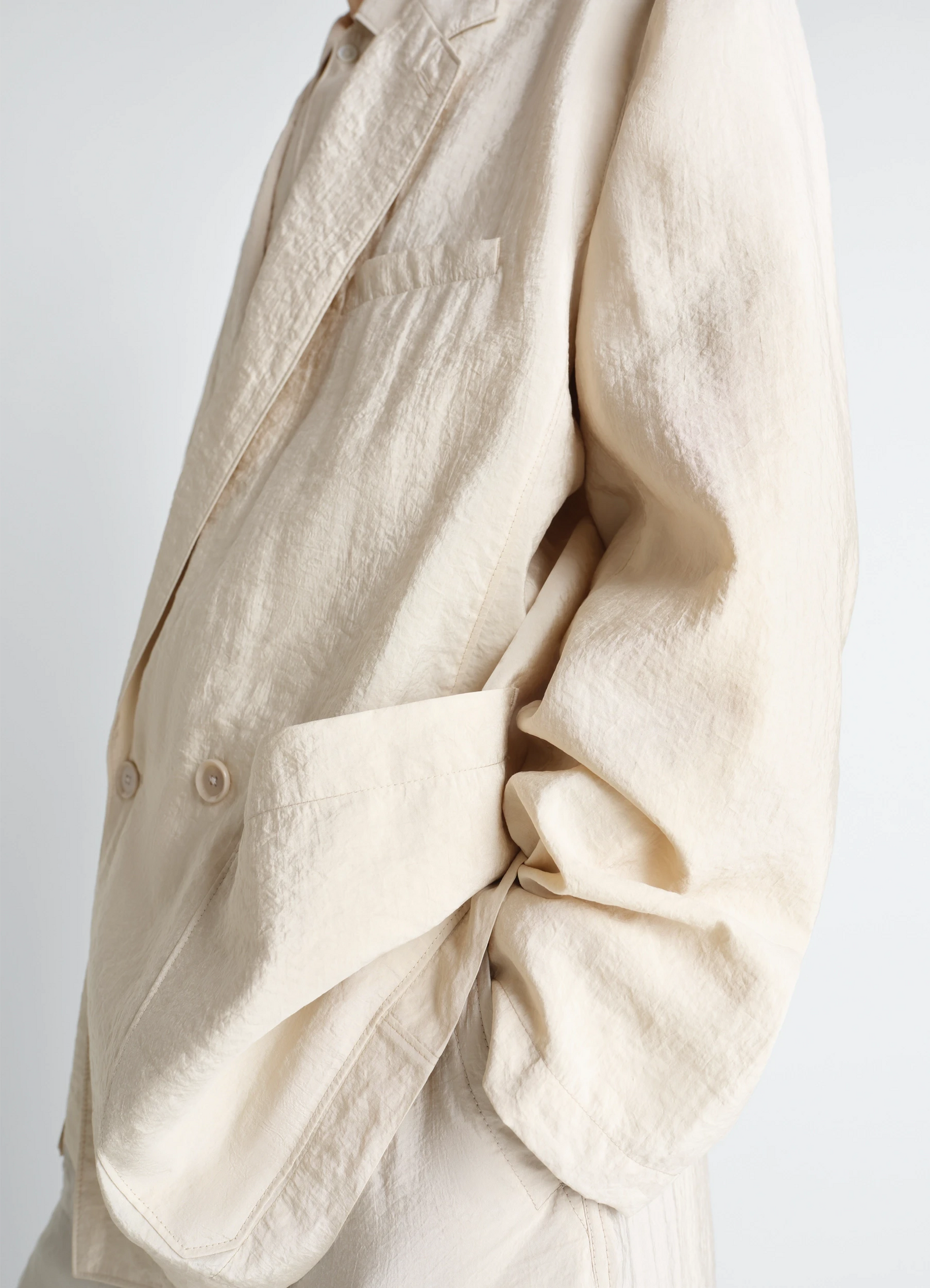 Soft double breasted jacket in dry silk, model shot, close-up side detail textured fabric