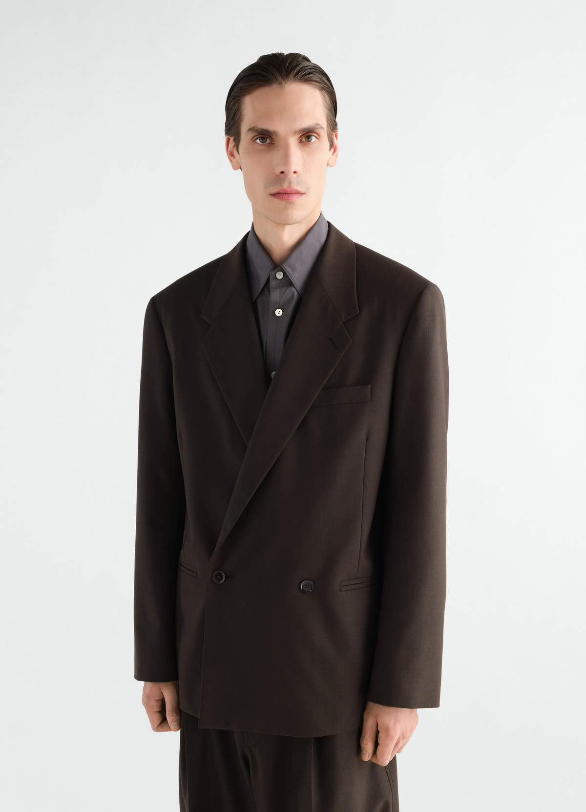 Double-breasted dark brown tropical wool jacket by lemaire worn by a model front view