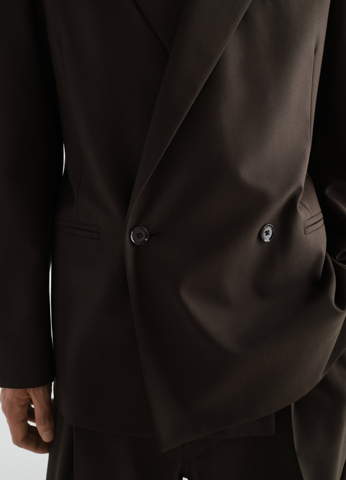 Double-breasted dark brown tropical wool blend jacket lemaire worn by a model front close-up detail
