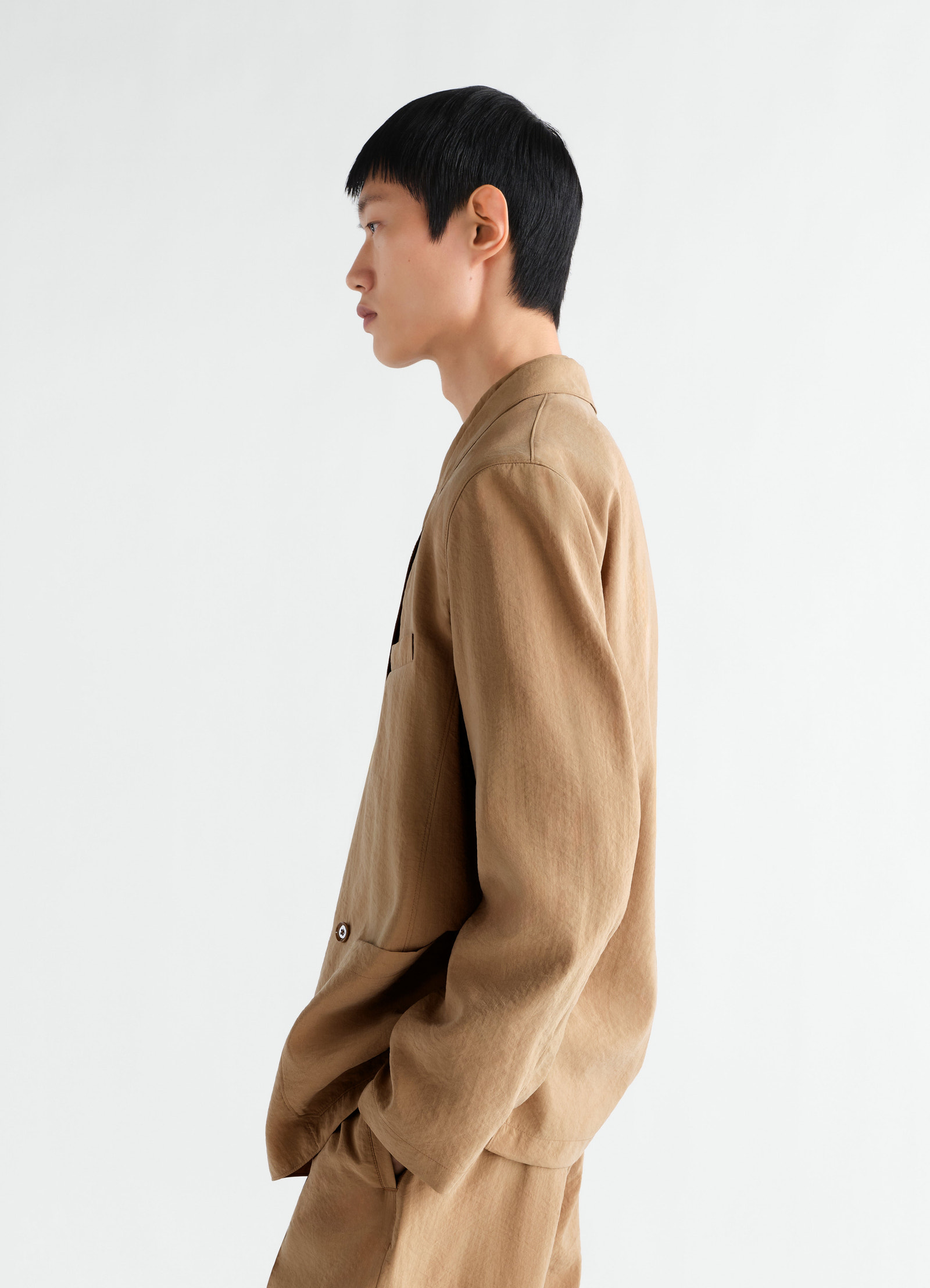 Light brown dry silk double-breasted jacket by lemaire worn by a model side view