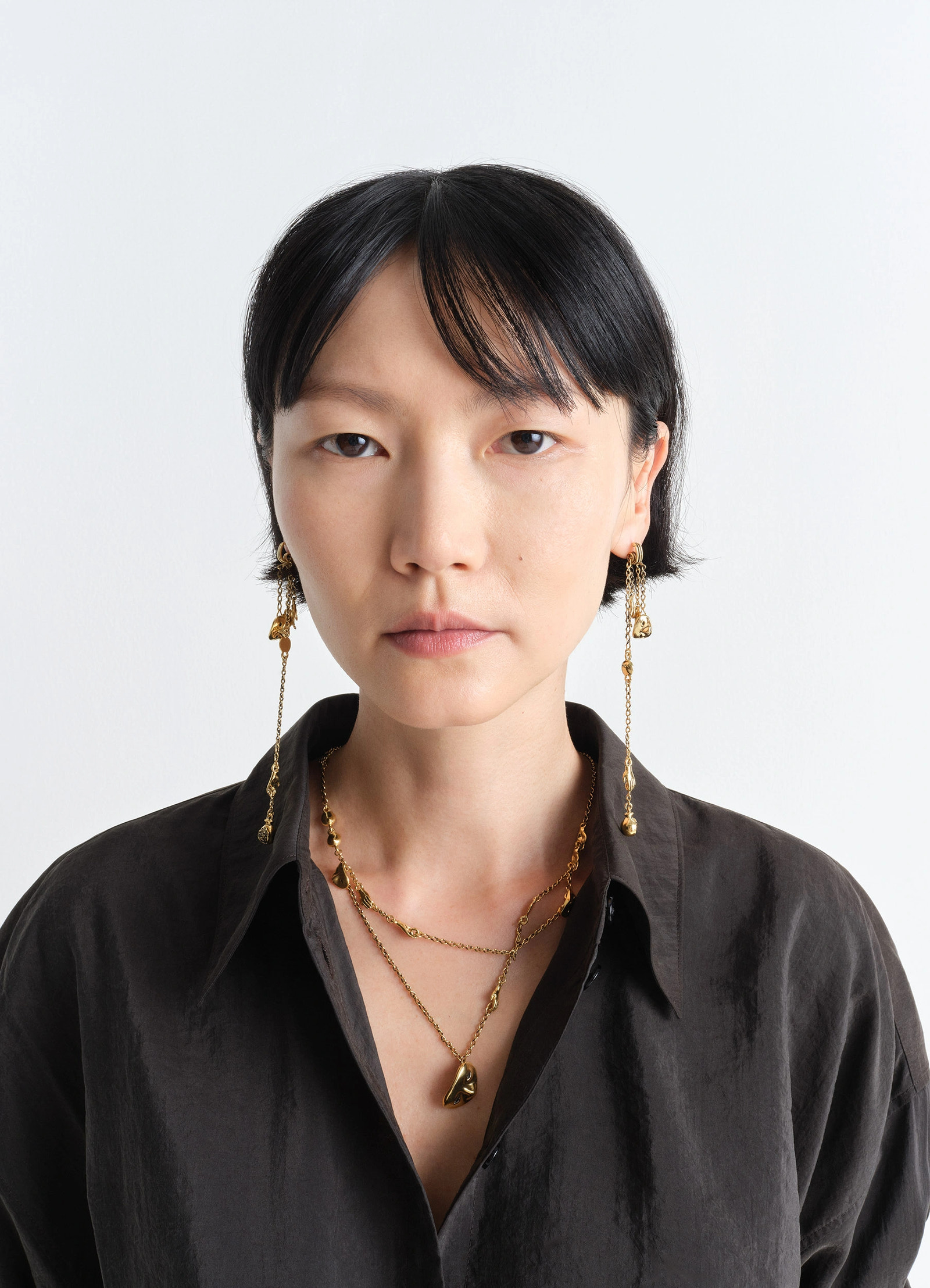 Estampe earrings in aged-effect gilded brass, model shot, three-quarter view intricate dangling chains