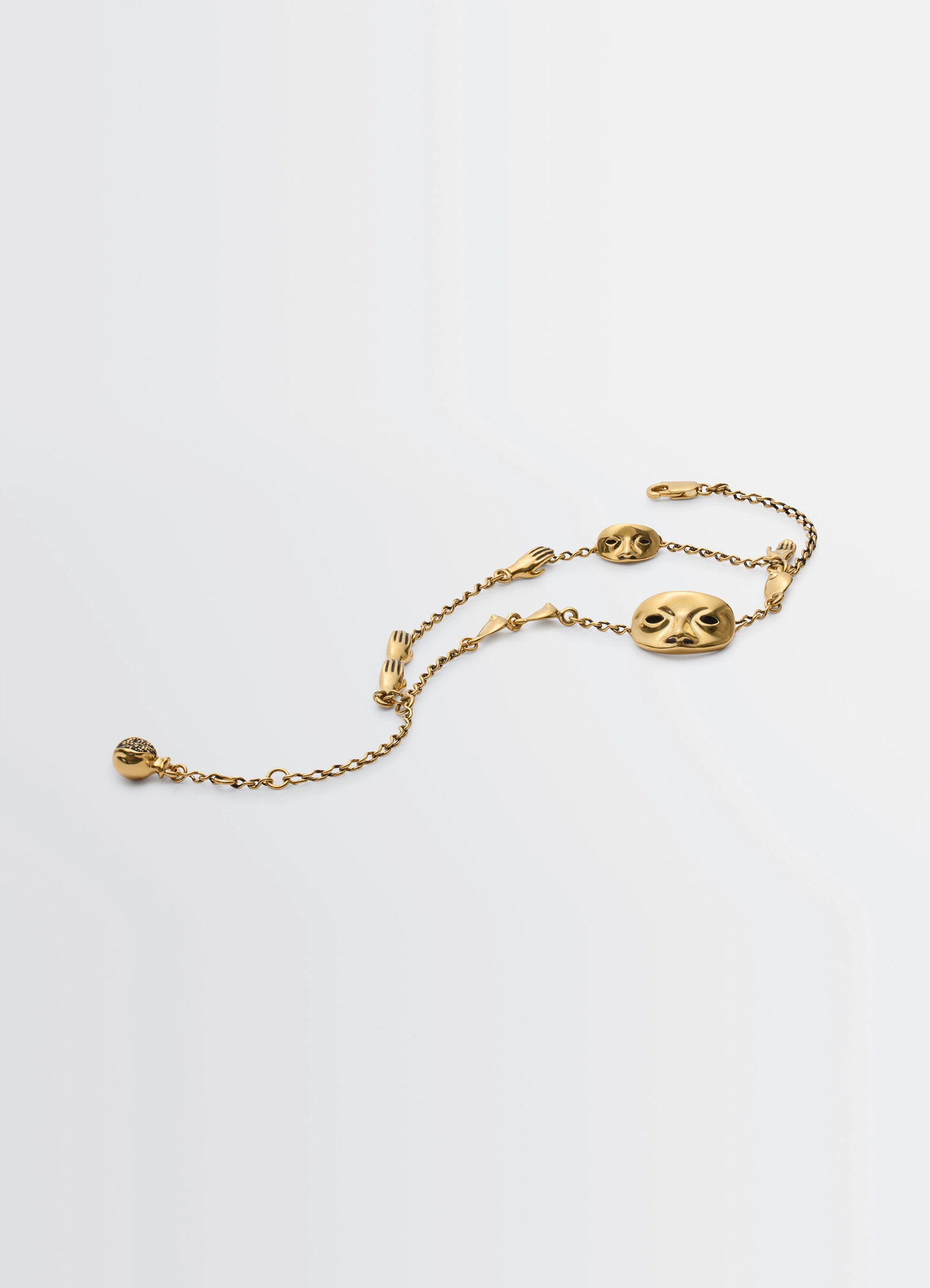 Estampe bracelet in aged-effect gold-plated brass, product shot, angled top view figurative charms detail