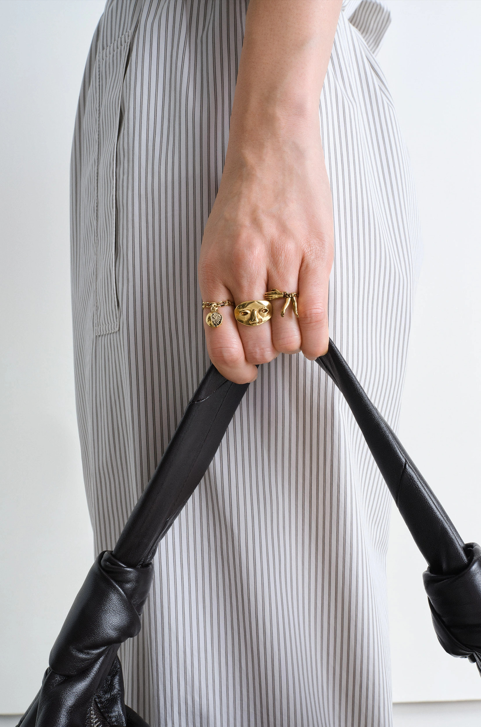 Estampe trio rings in aged-effect gilded brass, model shot, hand close-up sculptural motifs