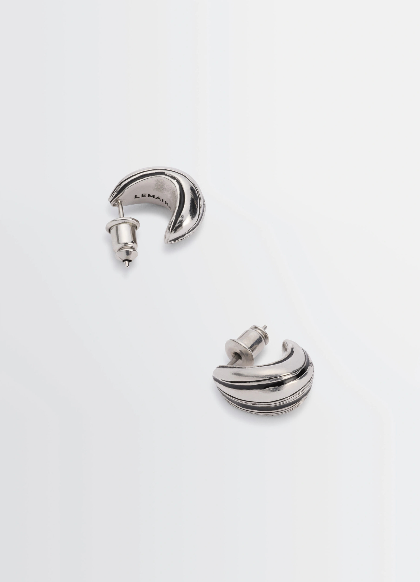 Girasol earrings in silver-plated brass, product shot, top-down view striped texture