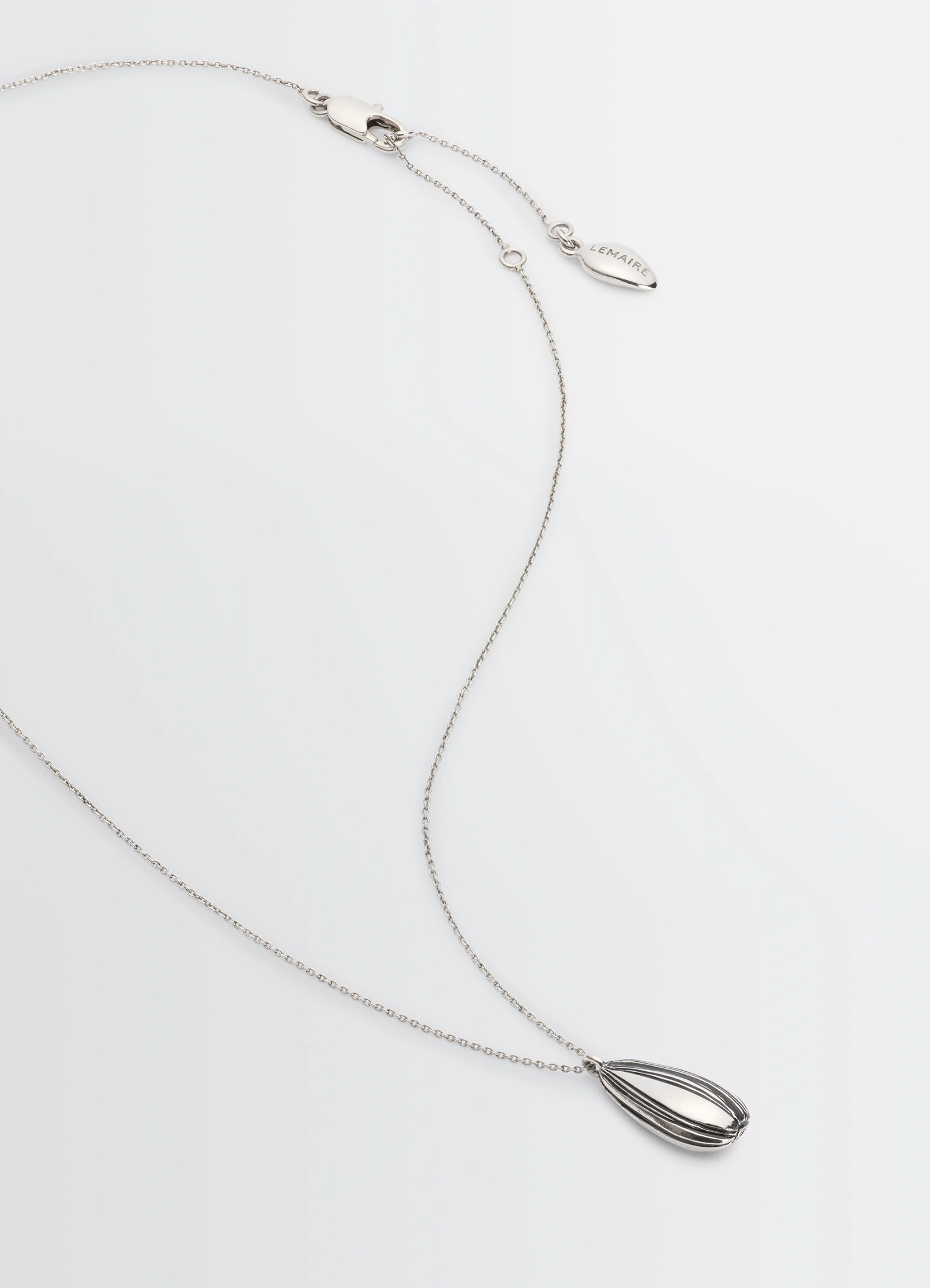 Girasol necklace in silver-plated brass, product shot, angled top view pendant with clasp detail