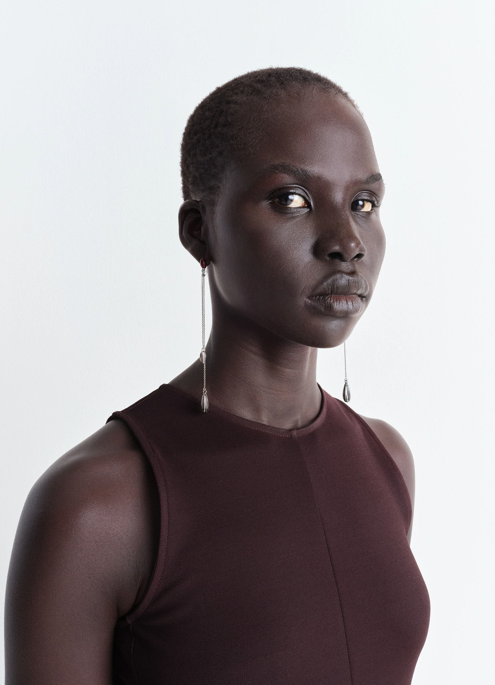 Asymmetric girasol earrings in silver-plated brass, model shot, side profile view long minimal chain