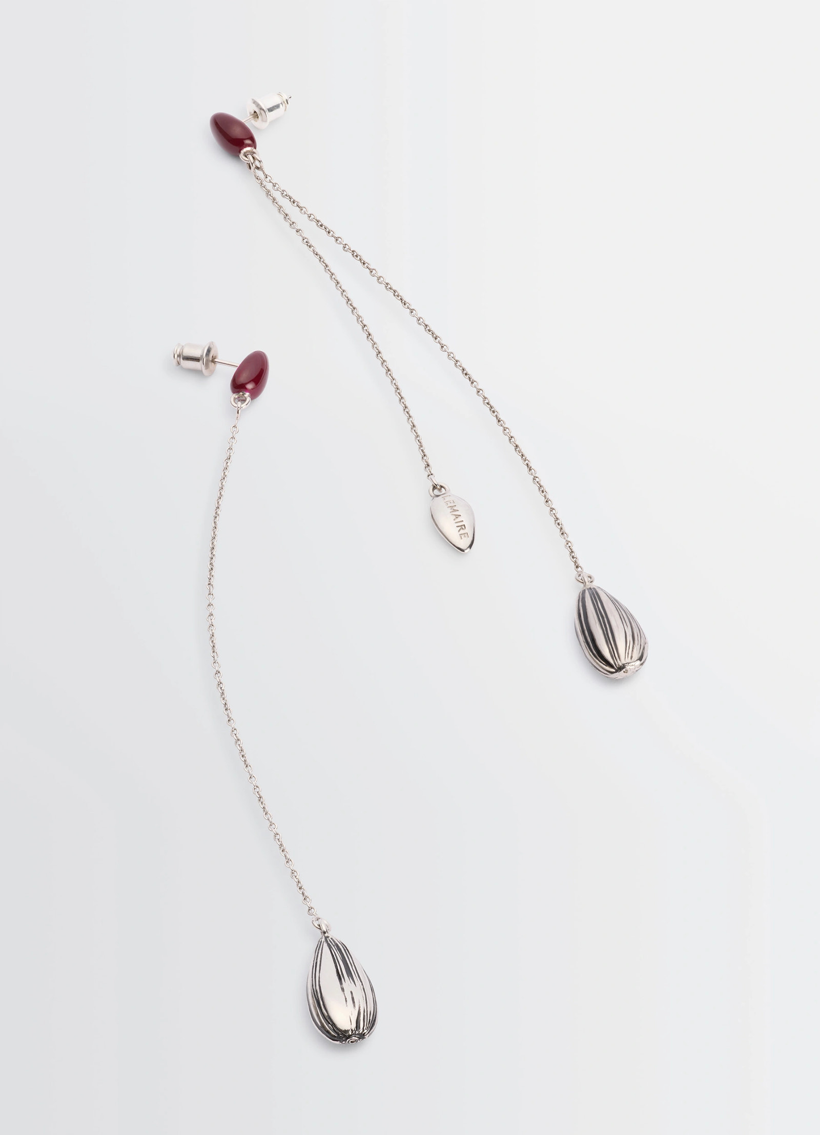 Asymmetric girasol earrings in silver-plated brass, product shot, angled overhead shot striped teardrop charms