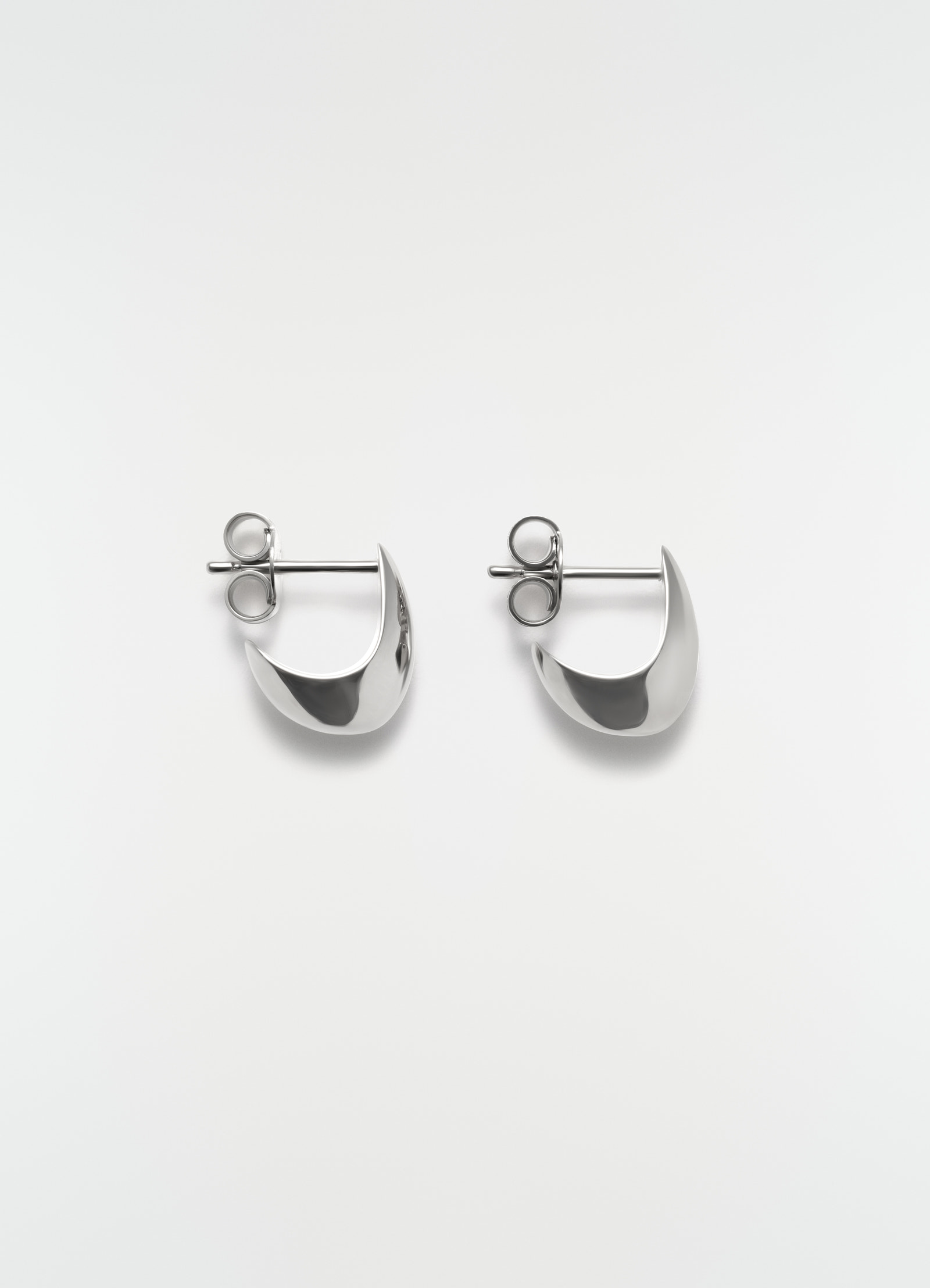Micro drop silver metal earrings by lemaire flat lay on white background showing front detail