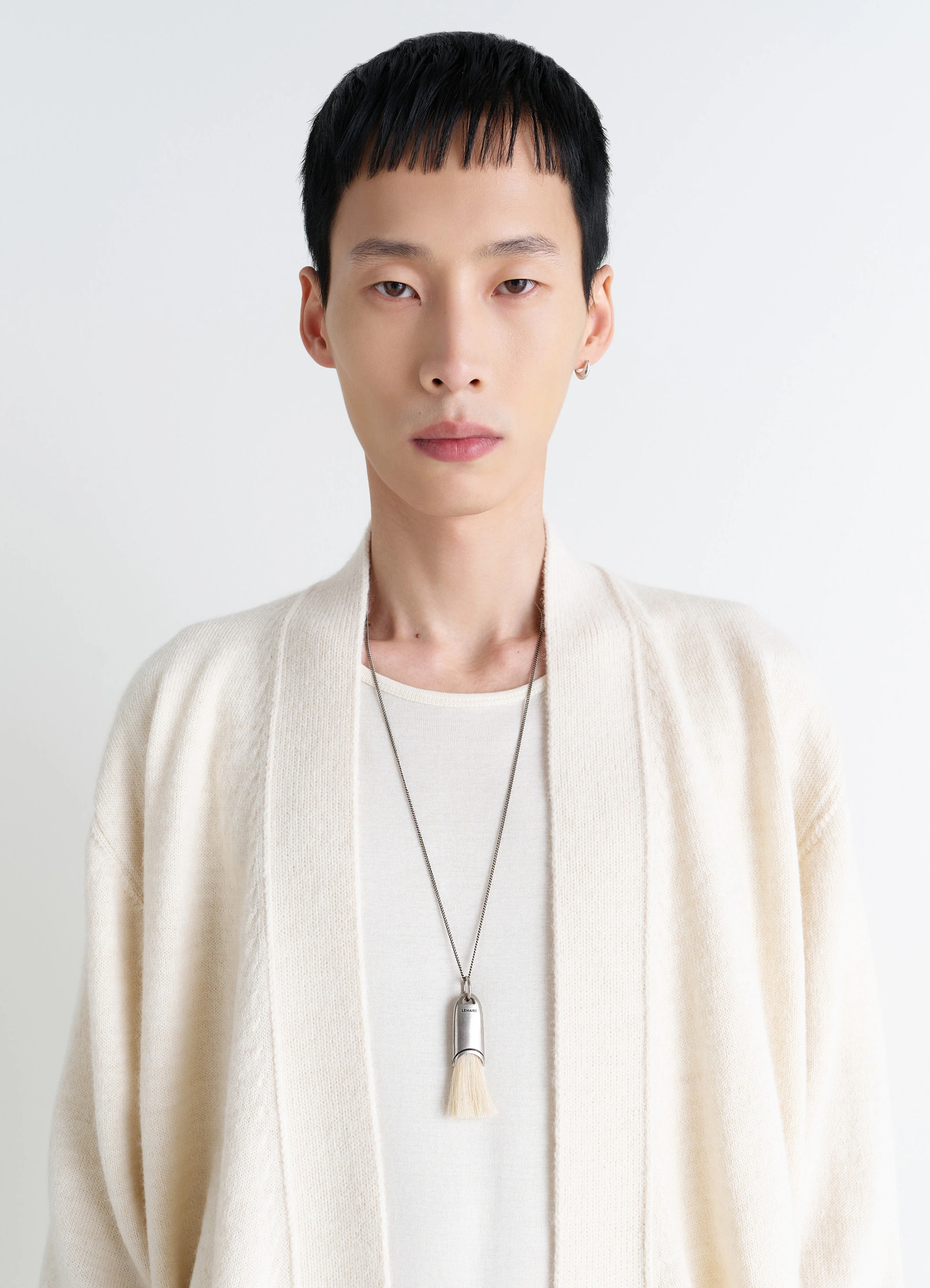 Lemaire personal brush necklace in silver and beige, model shot, porte close-up hanging brush pendant