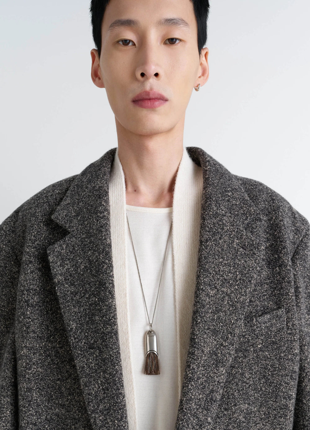Lemaire Personal Brush Necklace in Silver and Brown Brush, model shot, close-up front view worn over coat