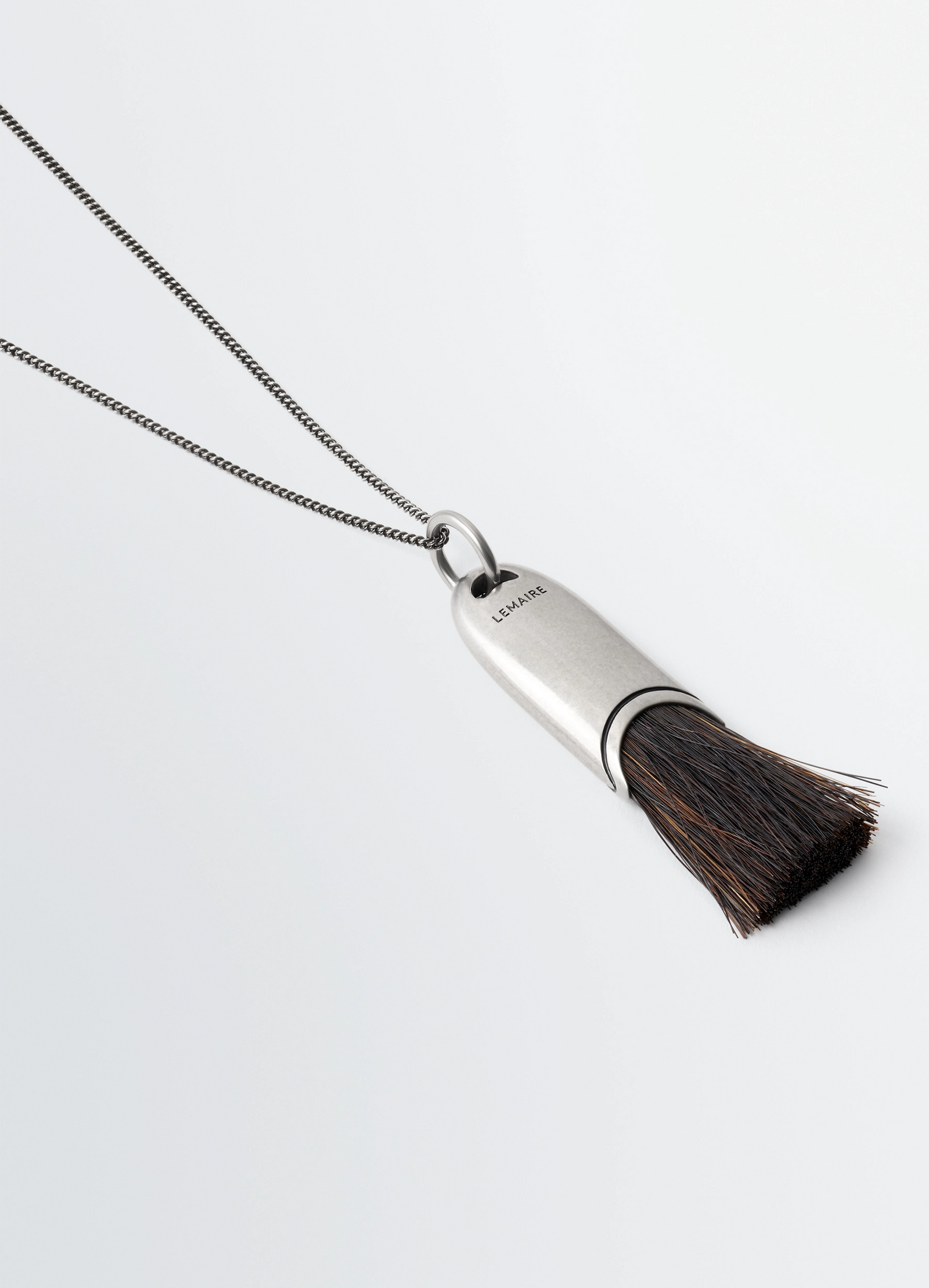Lemaire personal brush necklace in silver chain with brush pendant, product shot, angled detail shot sleek minimalist accent