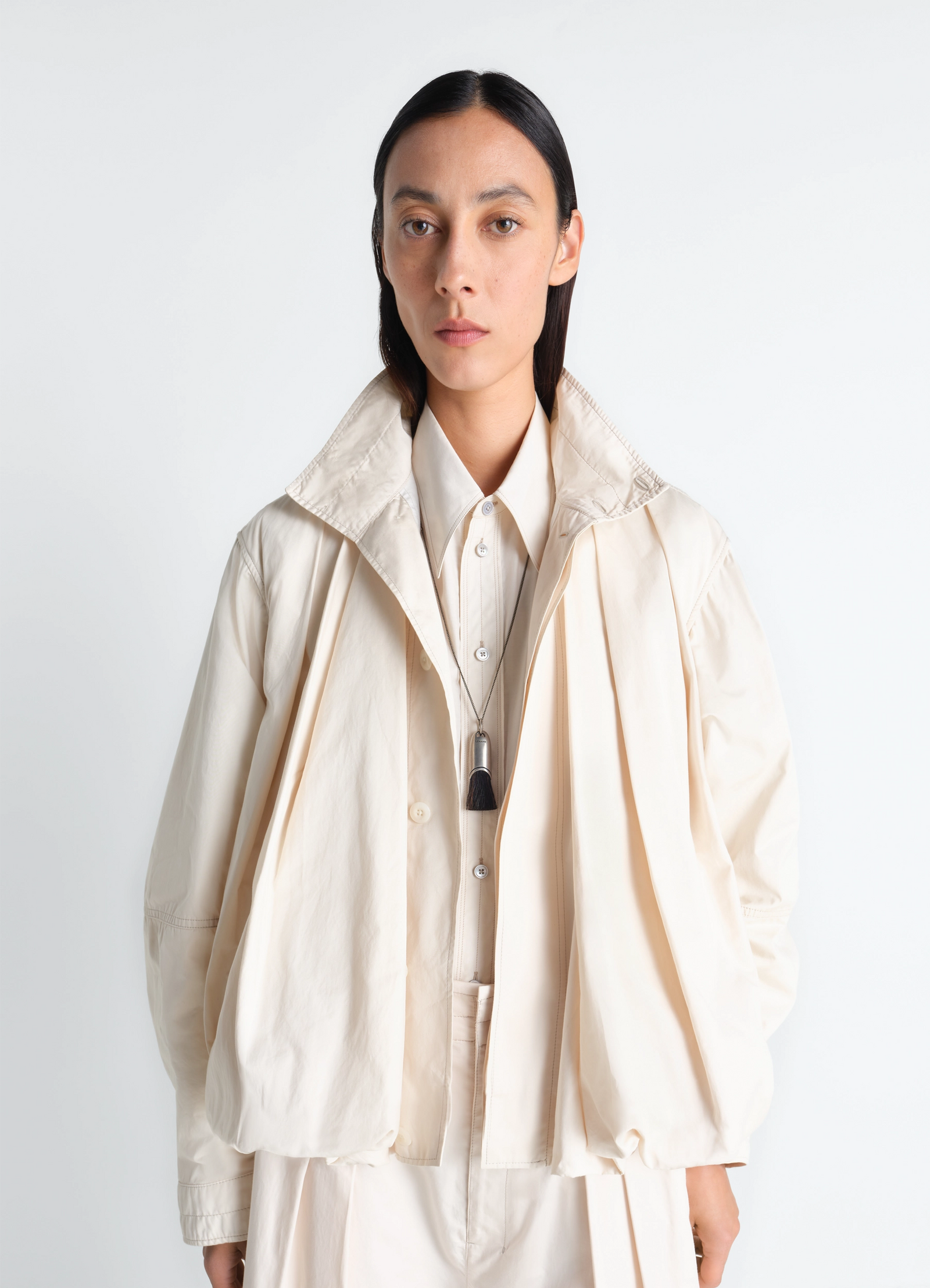 Lemaire personal brush necklace in silver chain with brush pendant, model shot, portrait view minimalist attire styling