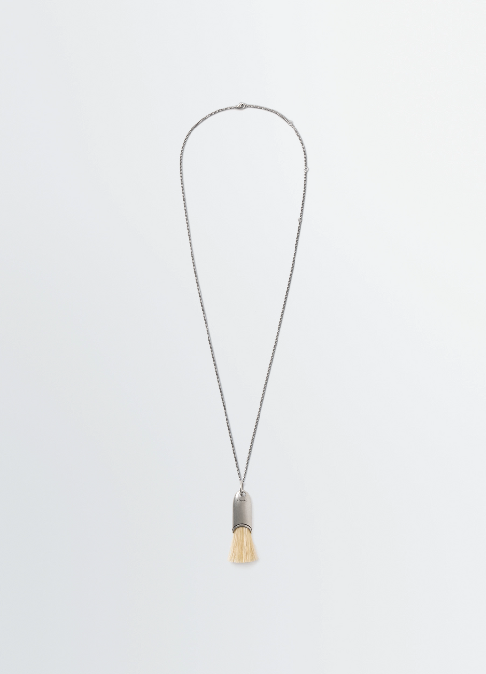 Personal brush necklace with silver chain and beige bristles LEMAIRE on plain white background