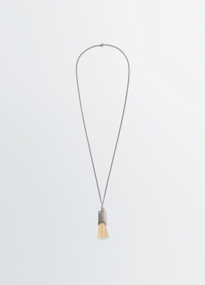Personal brush necklace with silver chain and beige bristles lemaire on plain white background