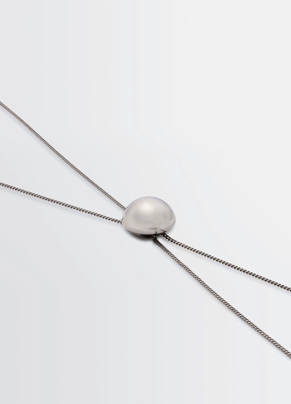 Lemaire Rattle Bolo Tie in Silver-plated Brass, product shot, angled close-up view minimalist design focus