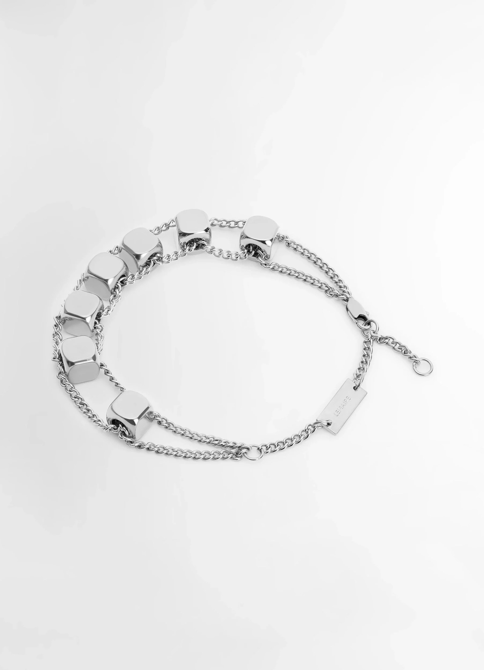 Abacus bracelet in shiny silver brass, product shot, angled overhead view triple chain links