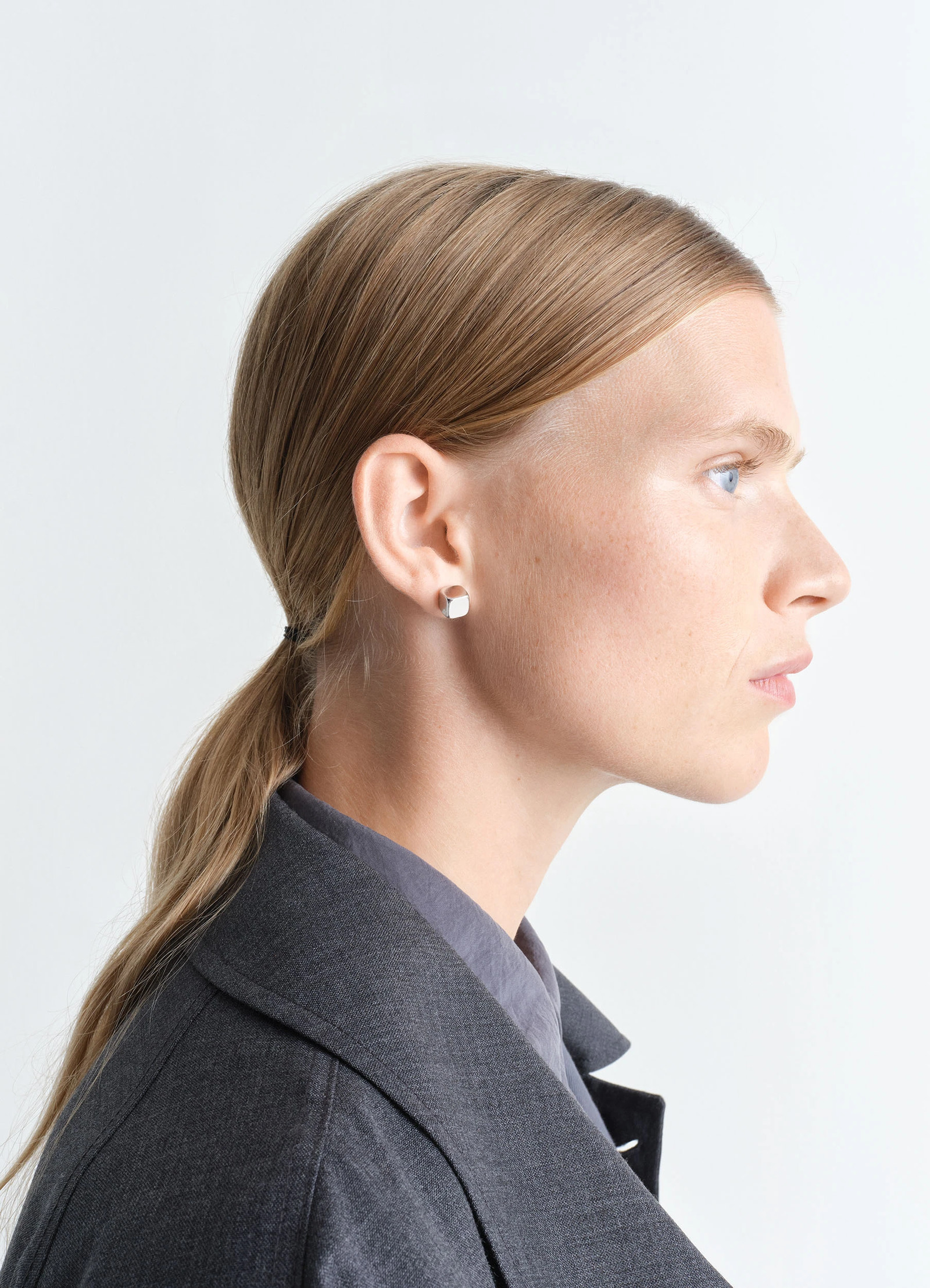 Lemaire abacus earrings in shiny silver brass, model shot, side view worn with gray blazer