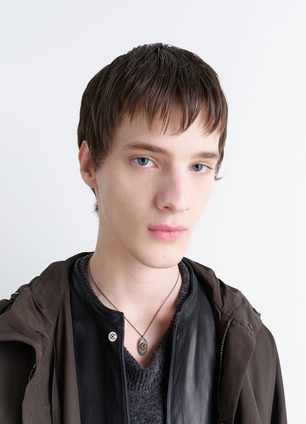 Cat Eye Pendant Necklace in Silver-plated brass, glass, model shot, worn close-up angle paired with layered jackets