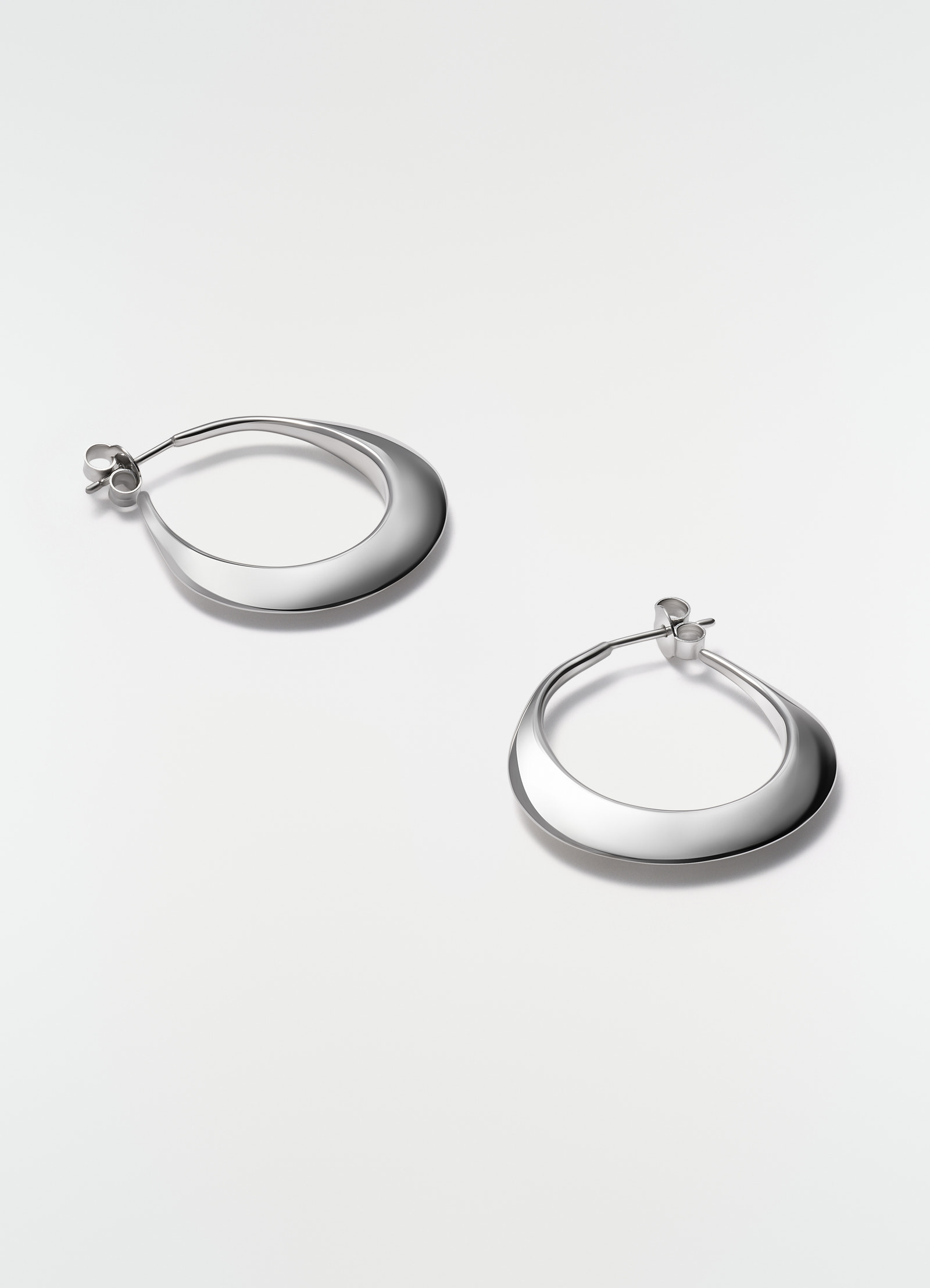 Hoops drop silver earrings in polished metal by lemaire styled flat on white background