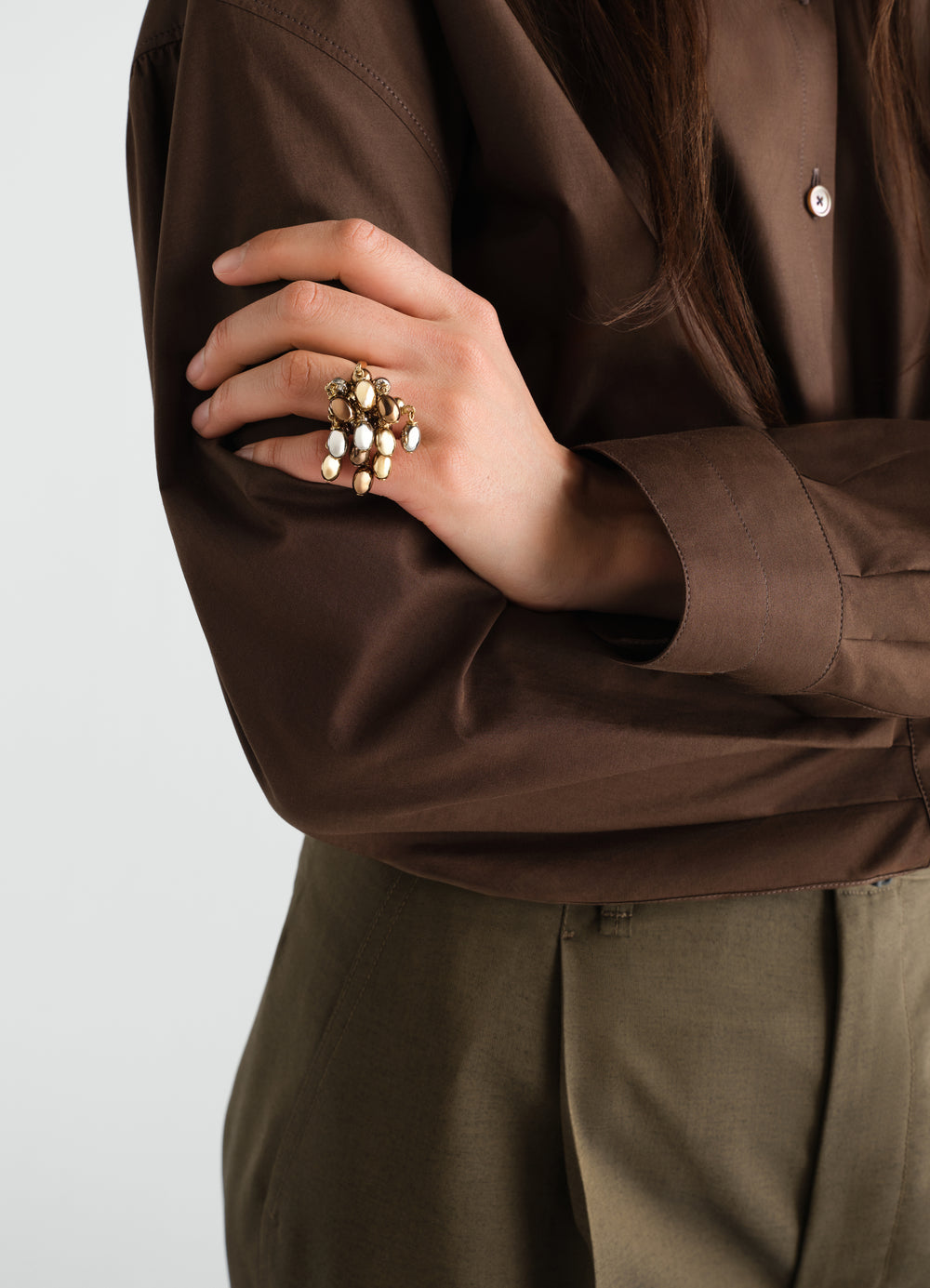Seeds Ring in gold-tone metal worn by a model with brown shirt and olive pants LEMAIRE close-up detail