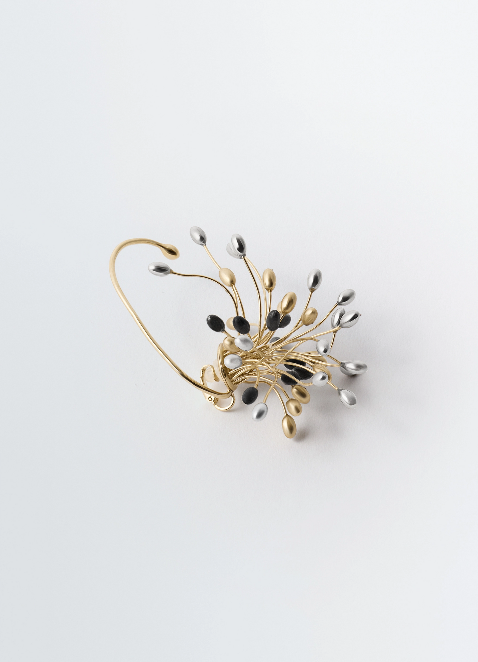 Seeds single earring in varied galvanic treatments, product shot, angled top view burst curl design