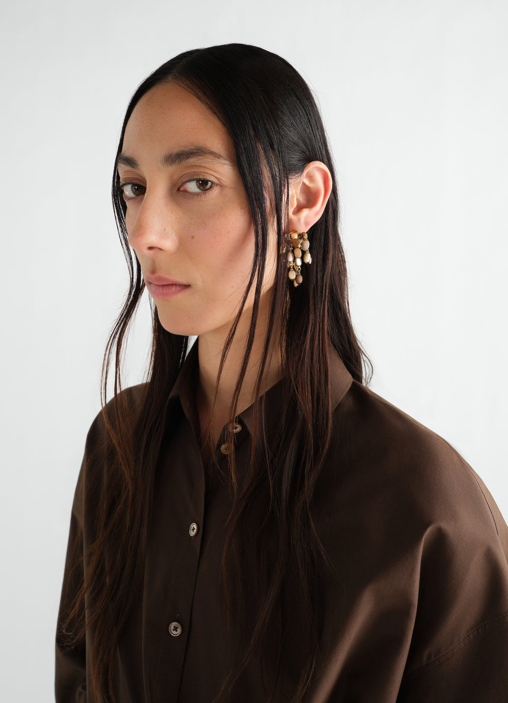 Seeds Earrings beige resin and brass close-up worn by model LEMAIRE