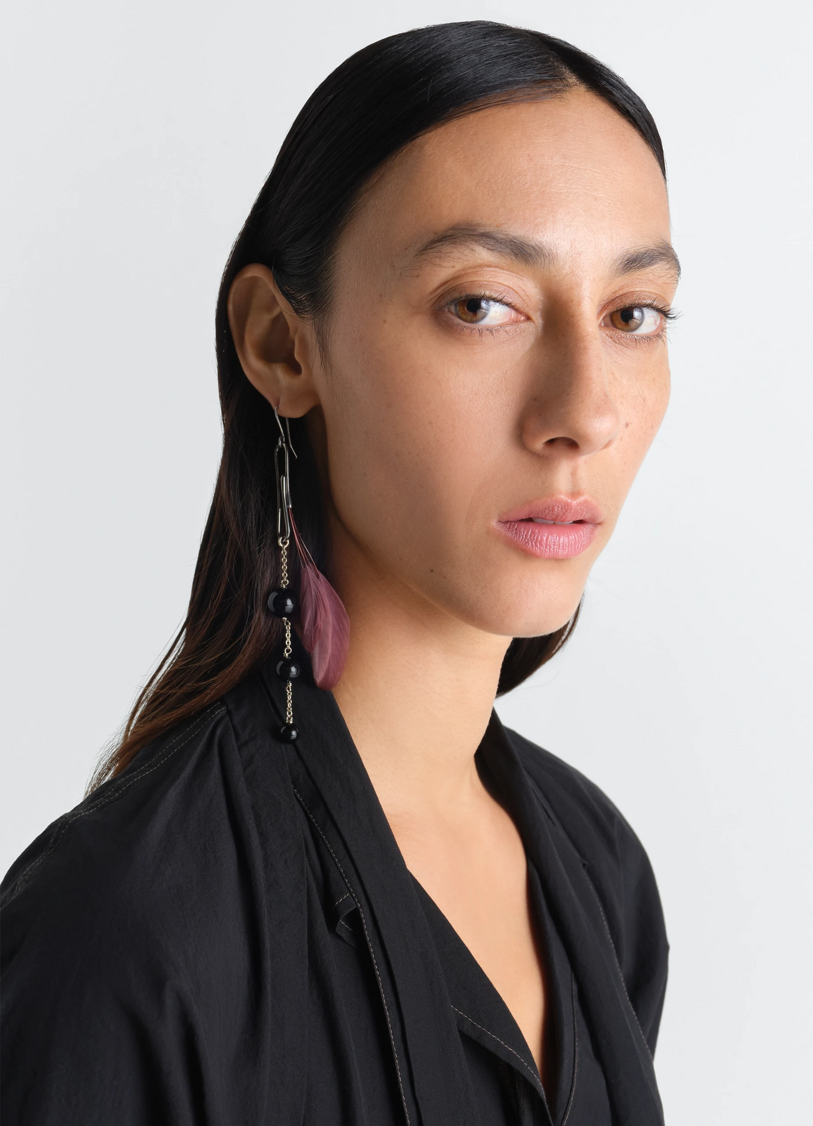 Dot earring with onyx and rooster f in onyx and rooster feather, model shot, side view elegant hanging charm