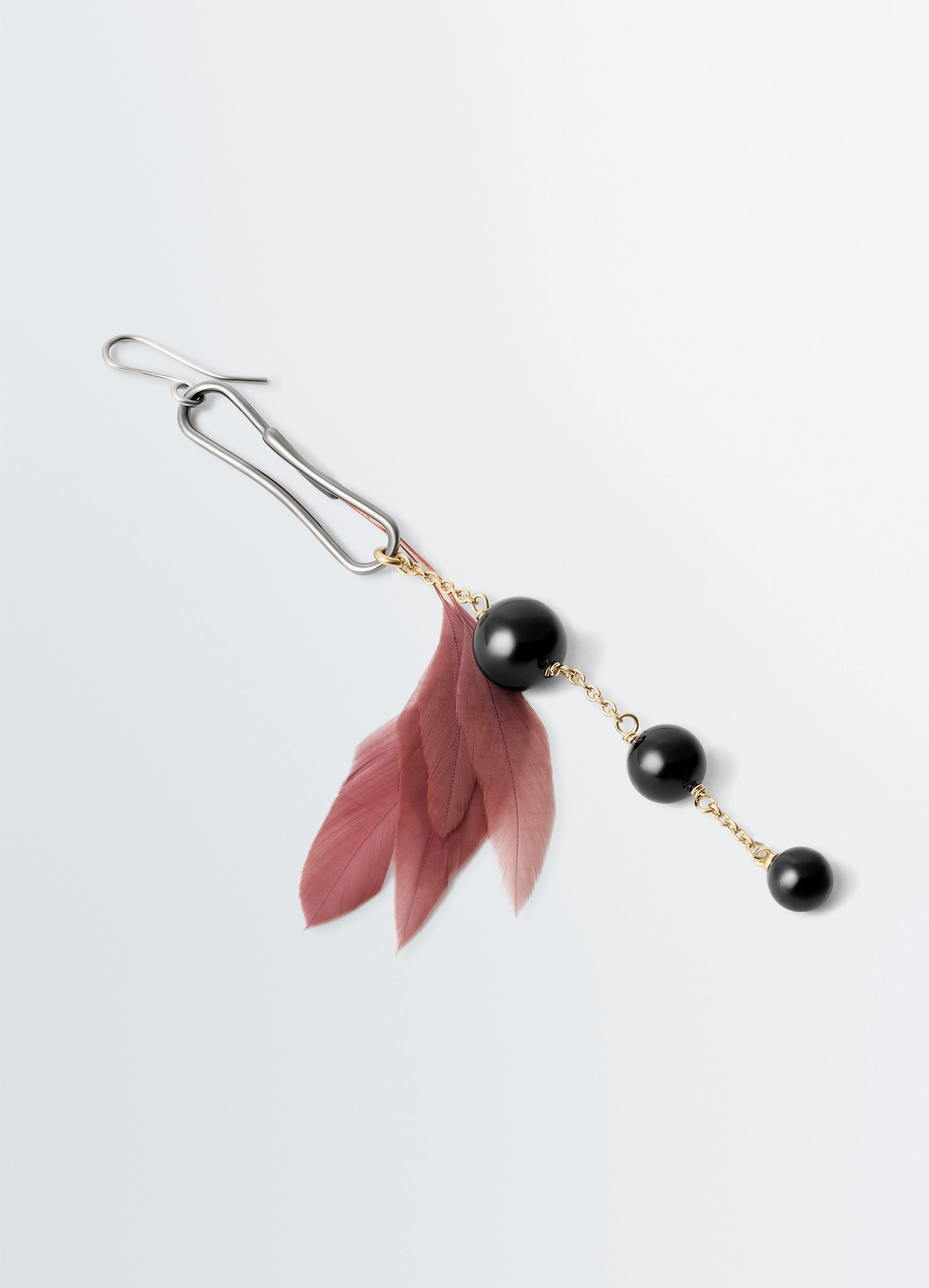 Dot earring with onyx and rooster f in onyx and rooster feather, product shot, top-down detail shot layered feather design