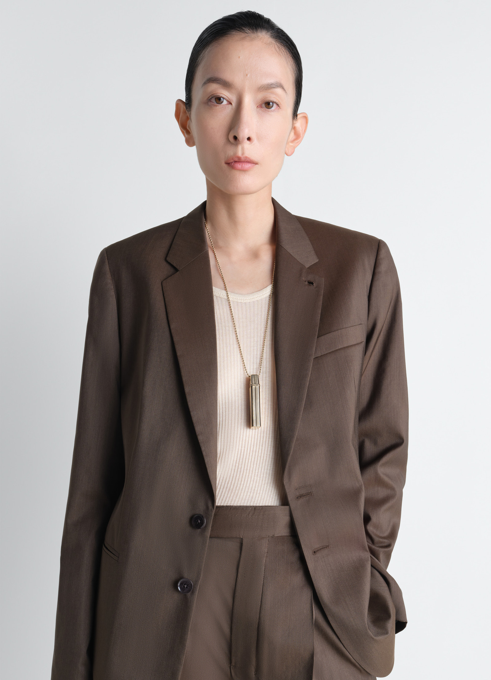 Carpenter pen necklace in brass, model shot, side view hanging on chest