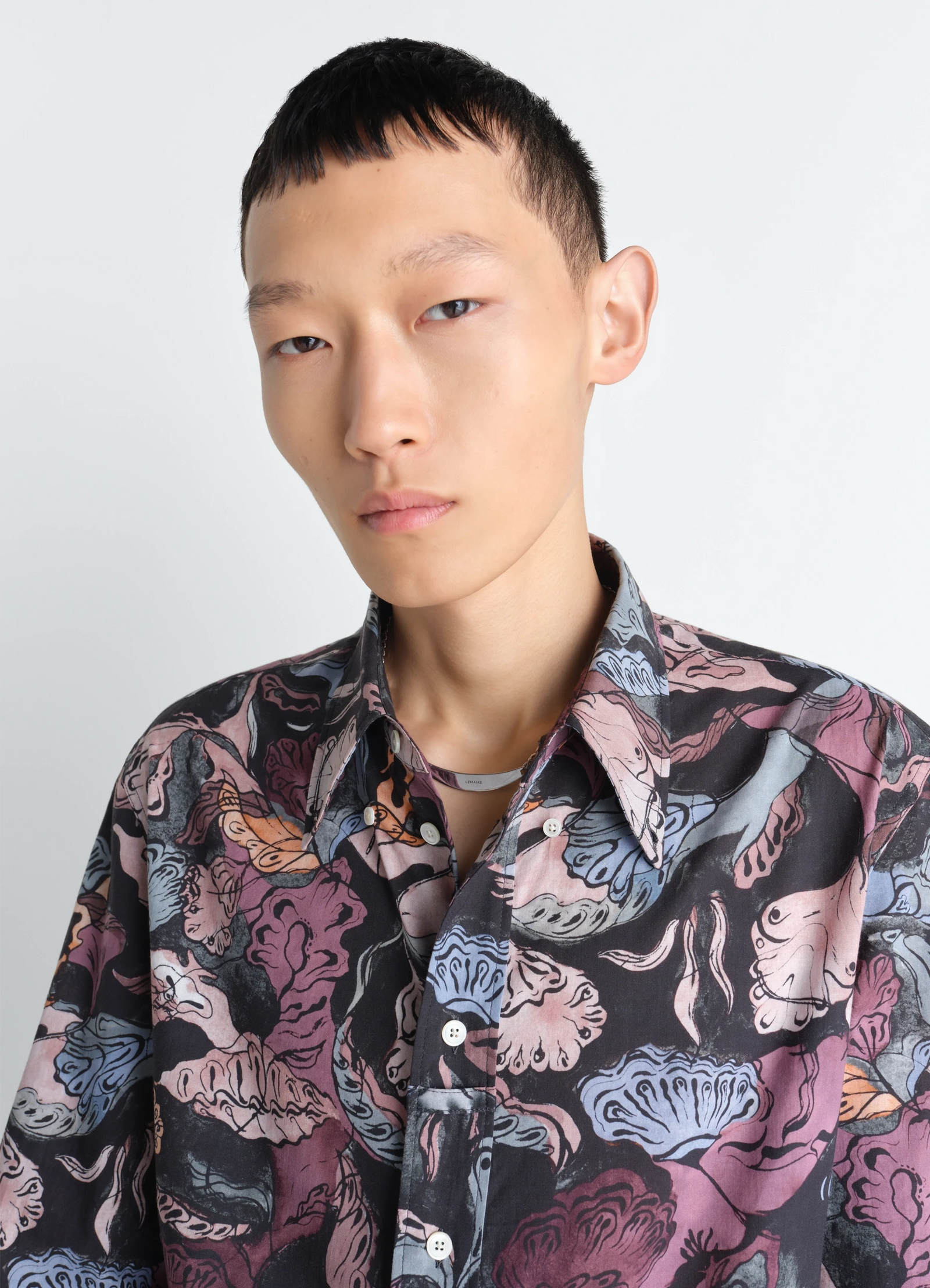 Id necklace in silver in silver sterling, model shot, side detail view layered over patterned shirt