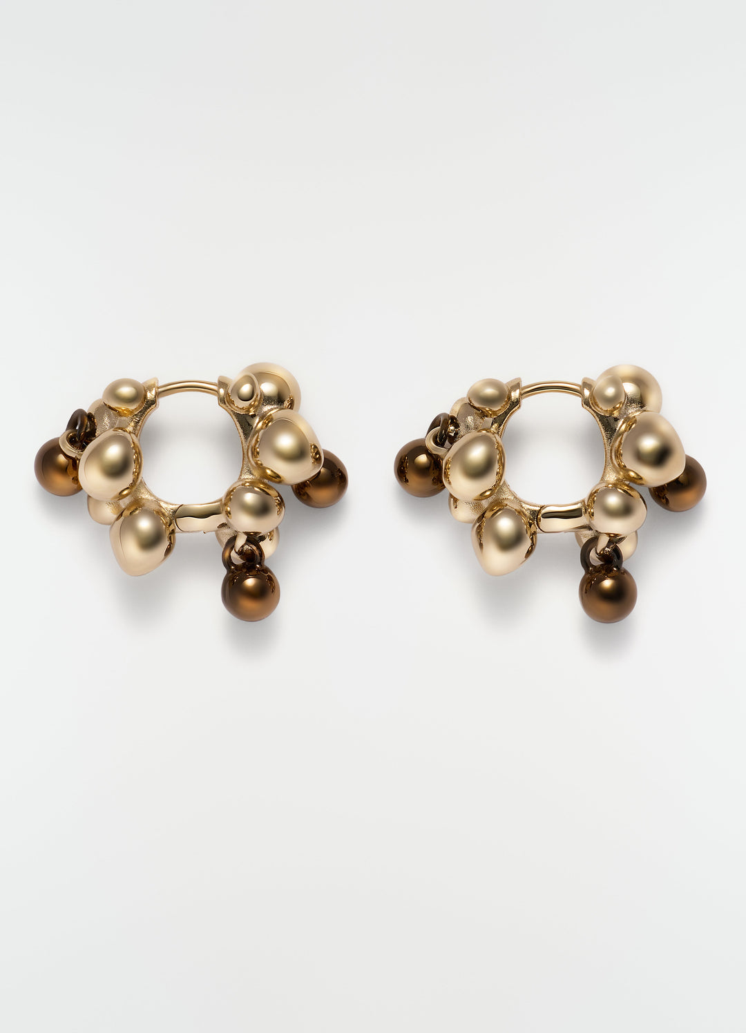 Seeds hoop earrings in gold-tone brass with brown beads by LEMAIRE, plain white background close-up