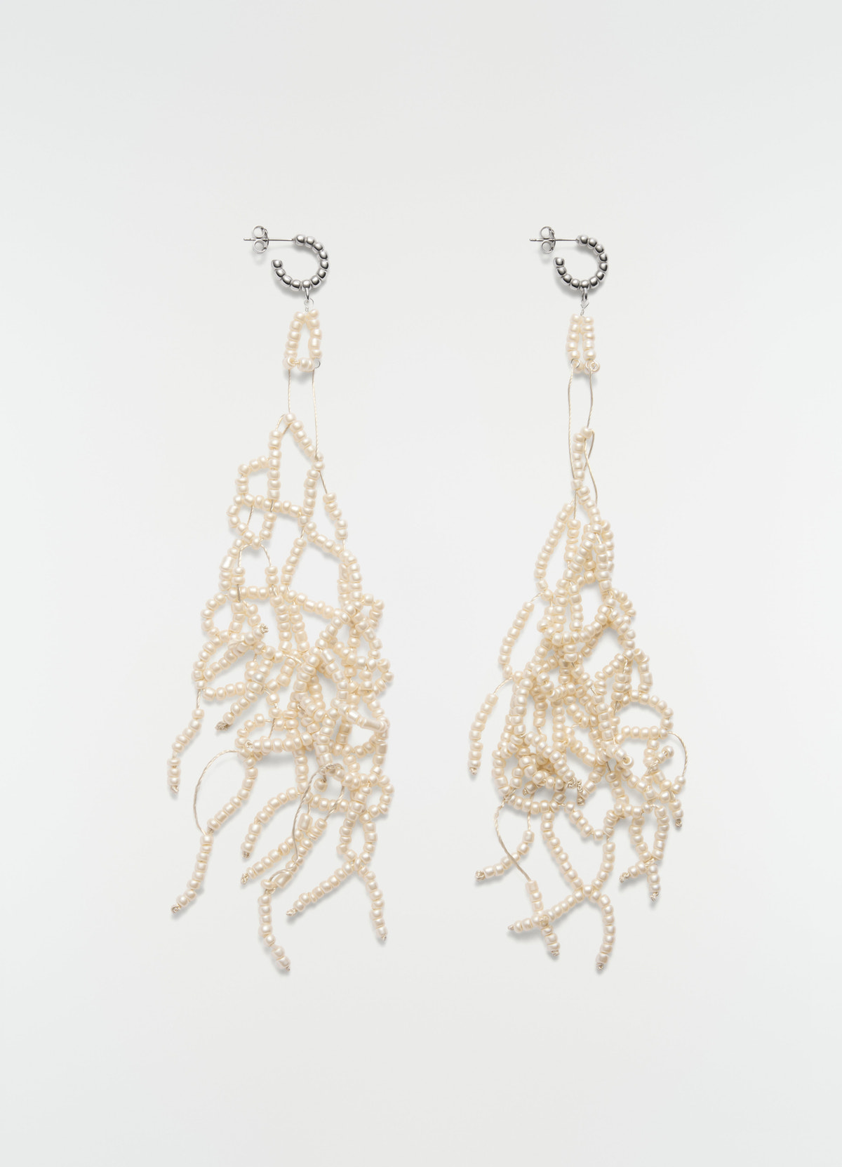 Boucles d'oreilles à pampilles en perles de verre, coloris crème, vue produit sur fond blanc, détails métalliques, franges visibles