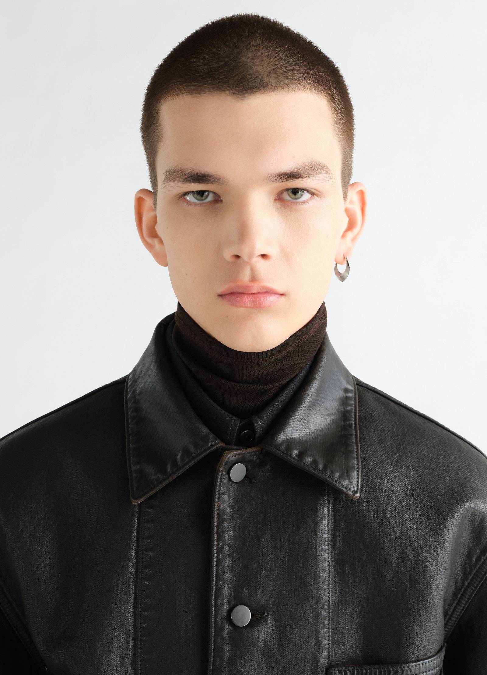 Drop edge hoop earrings in rhodium-plated silver worn by a model with black leather jacket lemaire front close-up